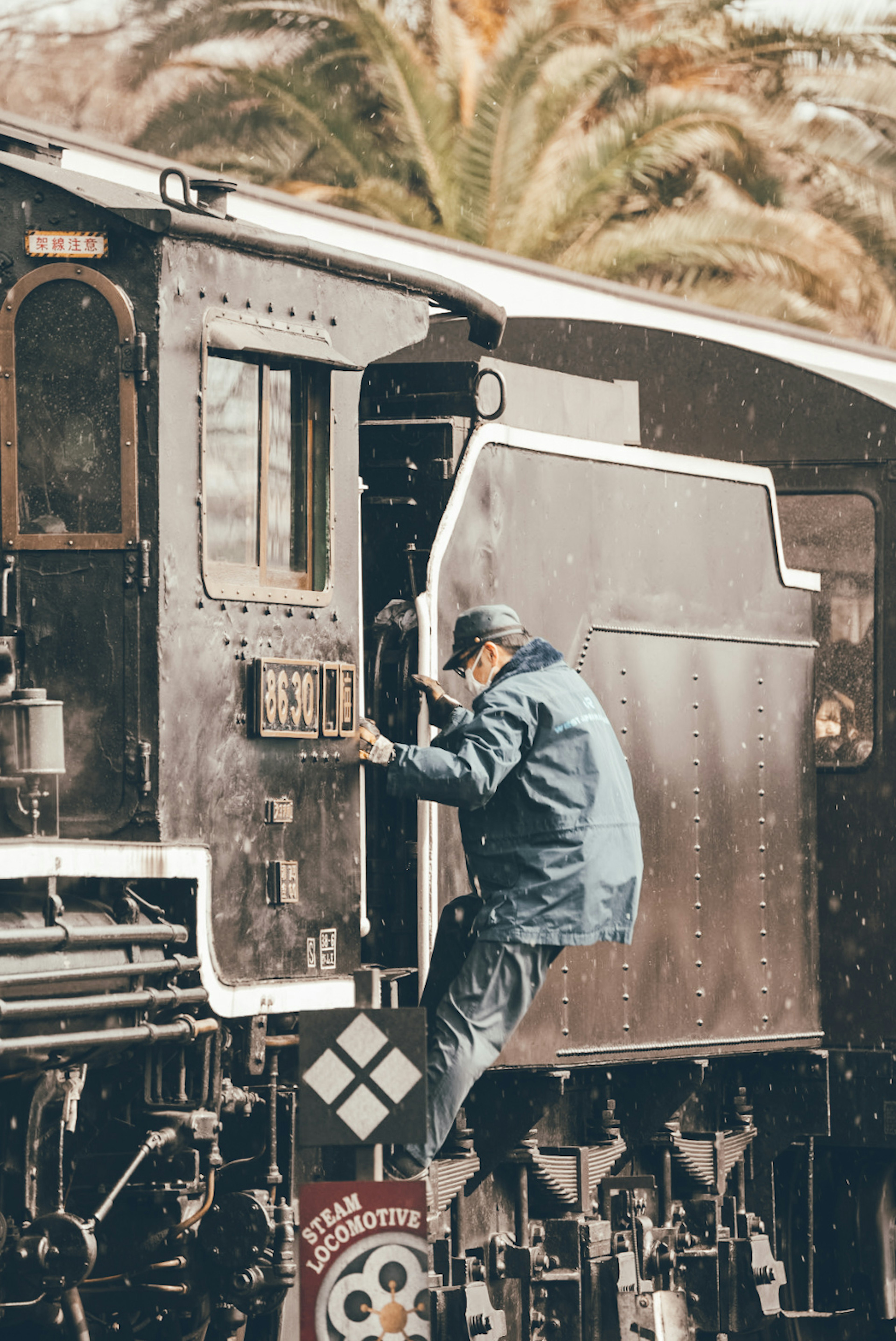 Train engineer climbing into a steam locomotive