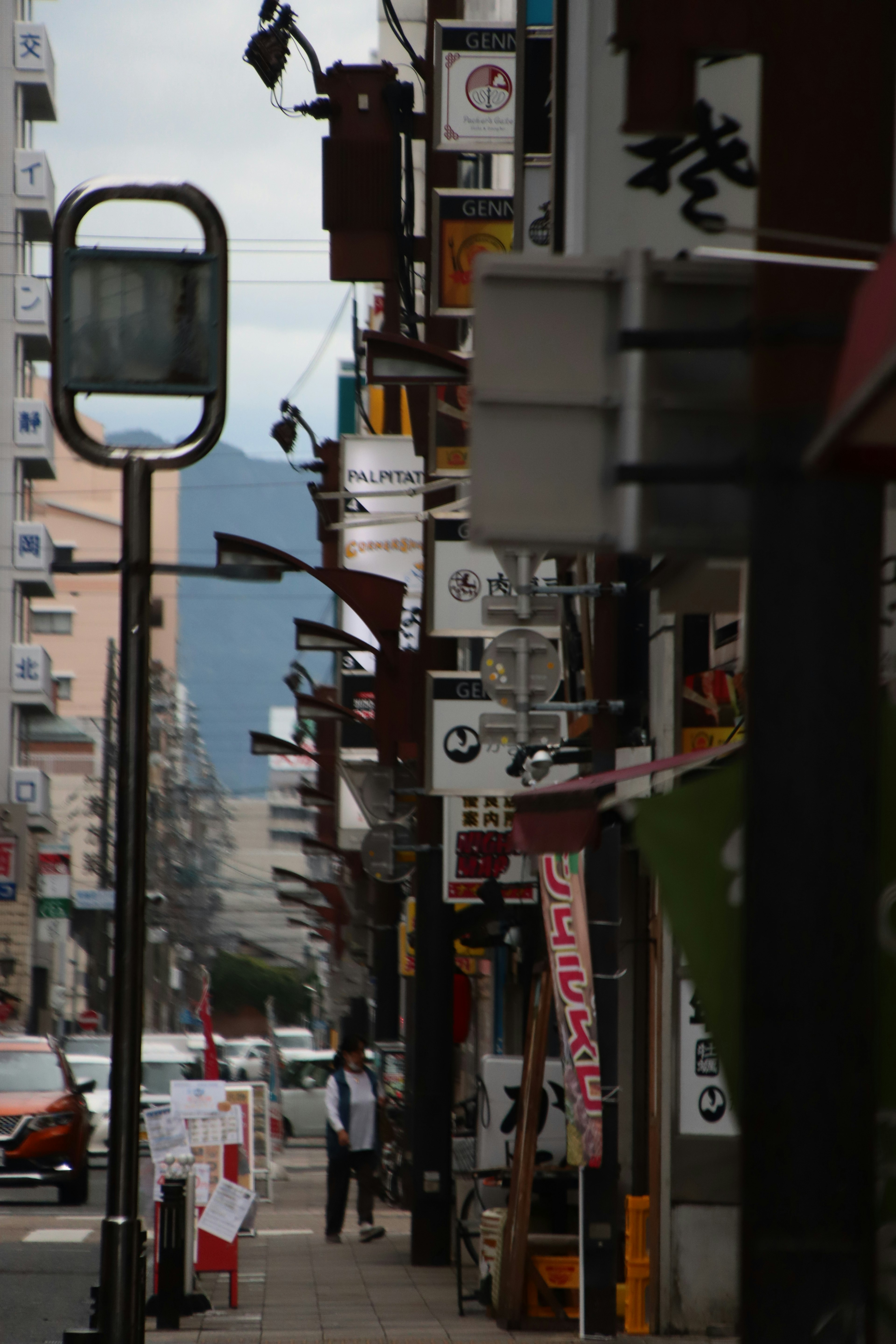 Schmale Straße mit Restaurantbeschilderungen und Straßenlaternen