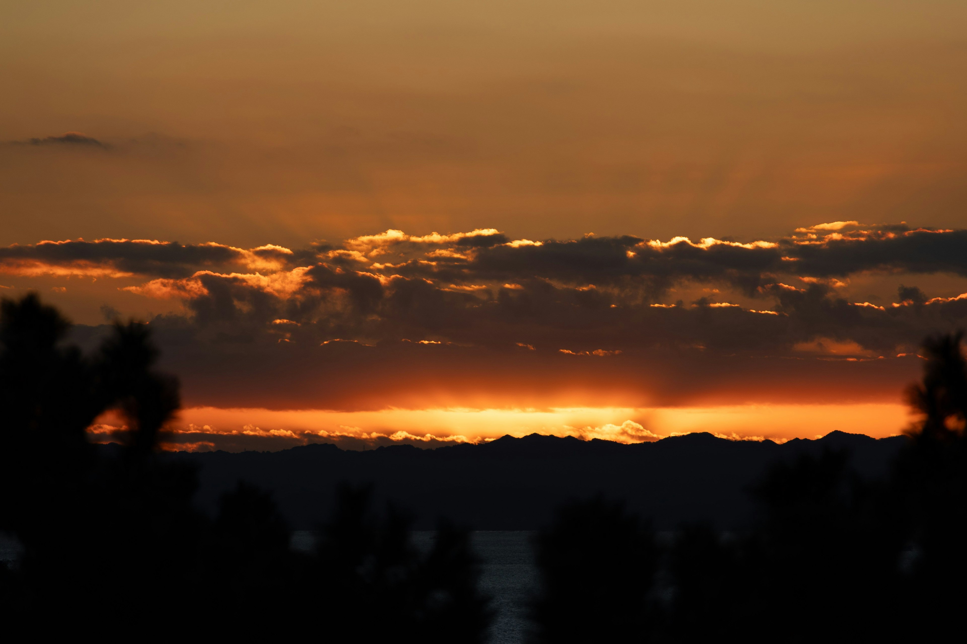 夕焼けの美しい風景、山々のシルエット、オレンジと紫の空