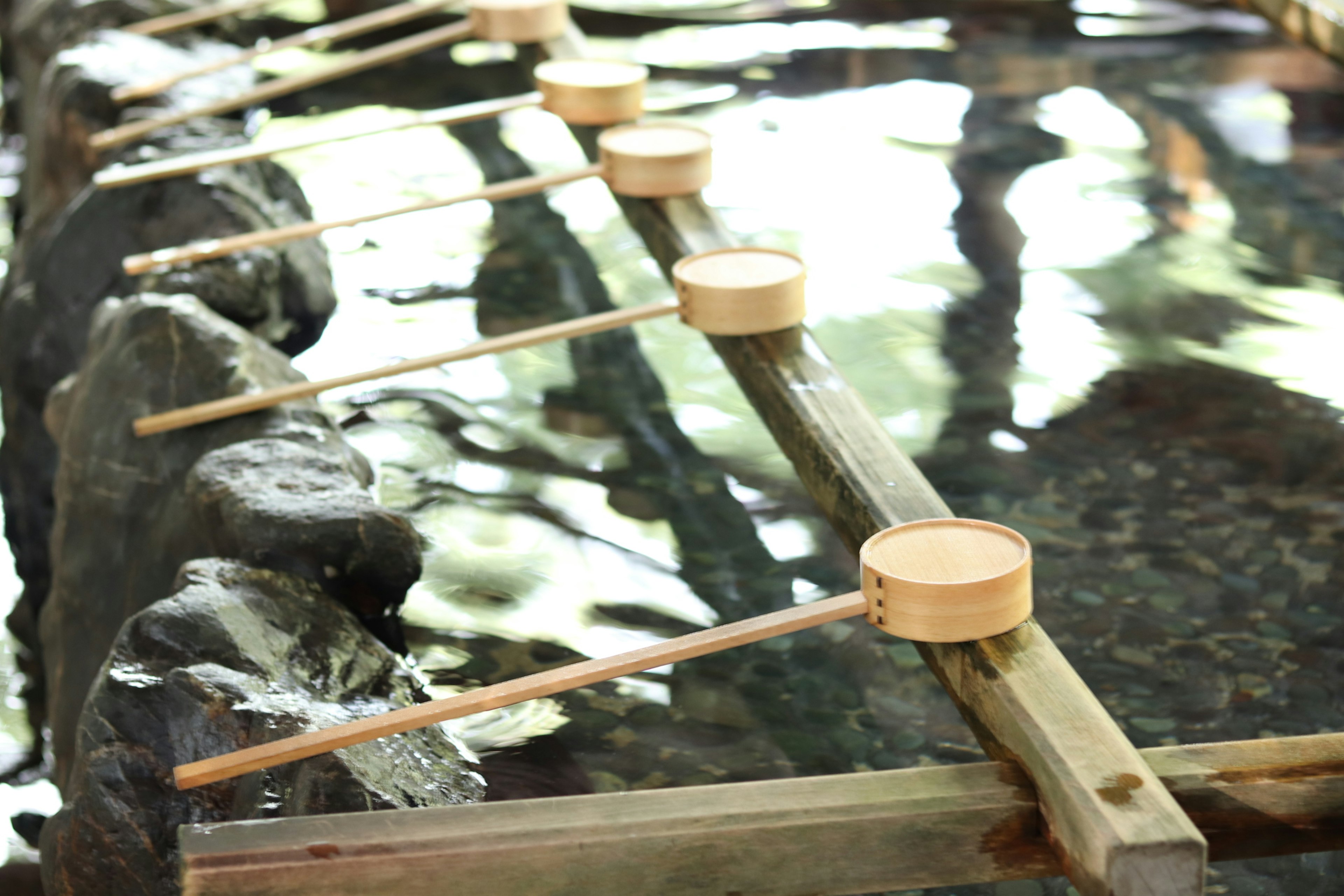 Ladles in bamboo posizionate su travi di legno sopra l'acqua