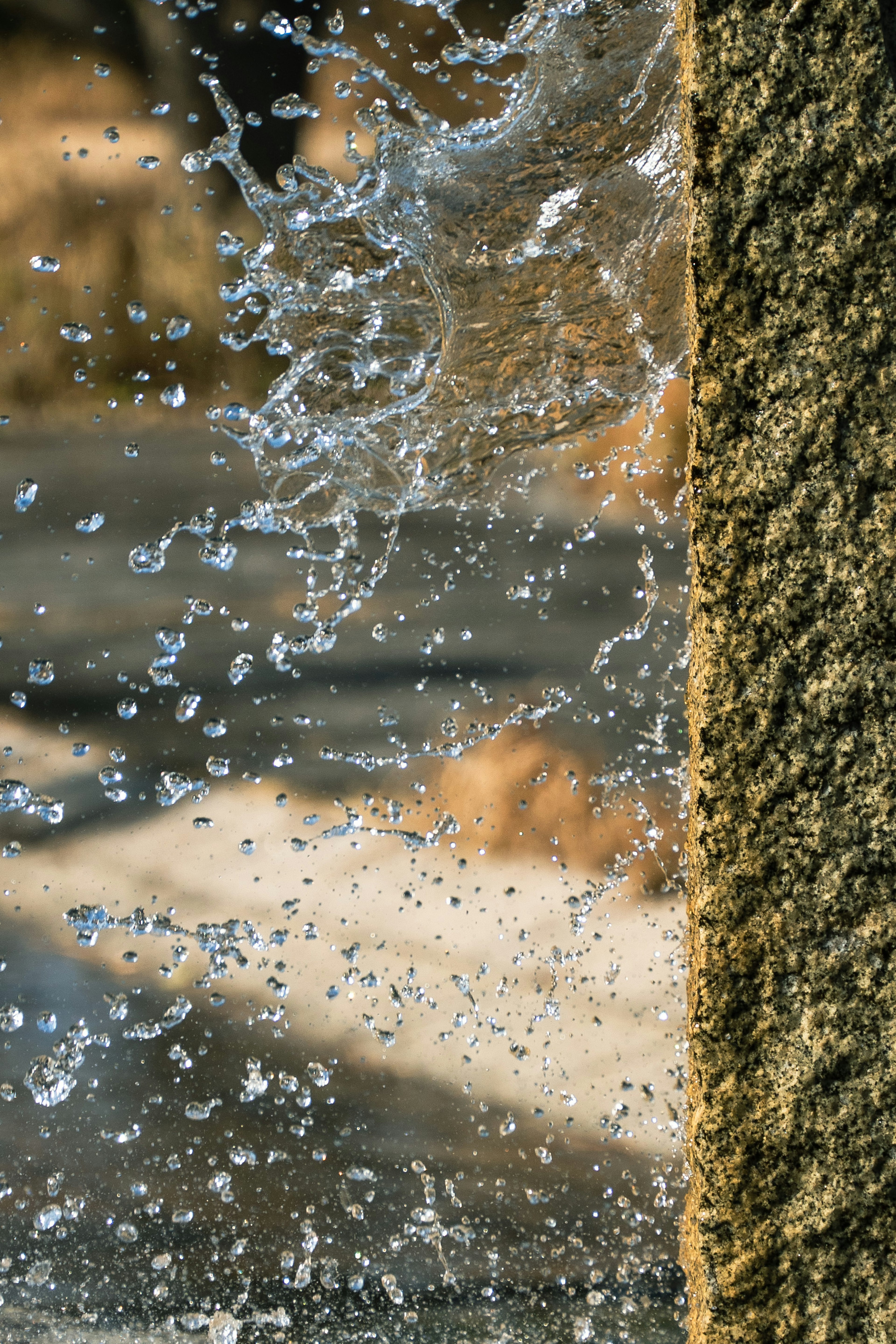 Acercamiento al agua salpicando cerca de un pilar de piedra