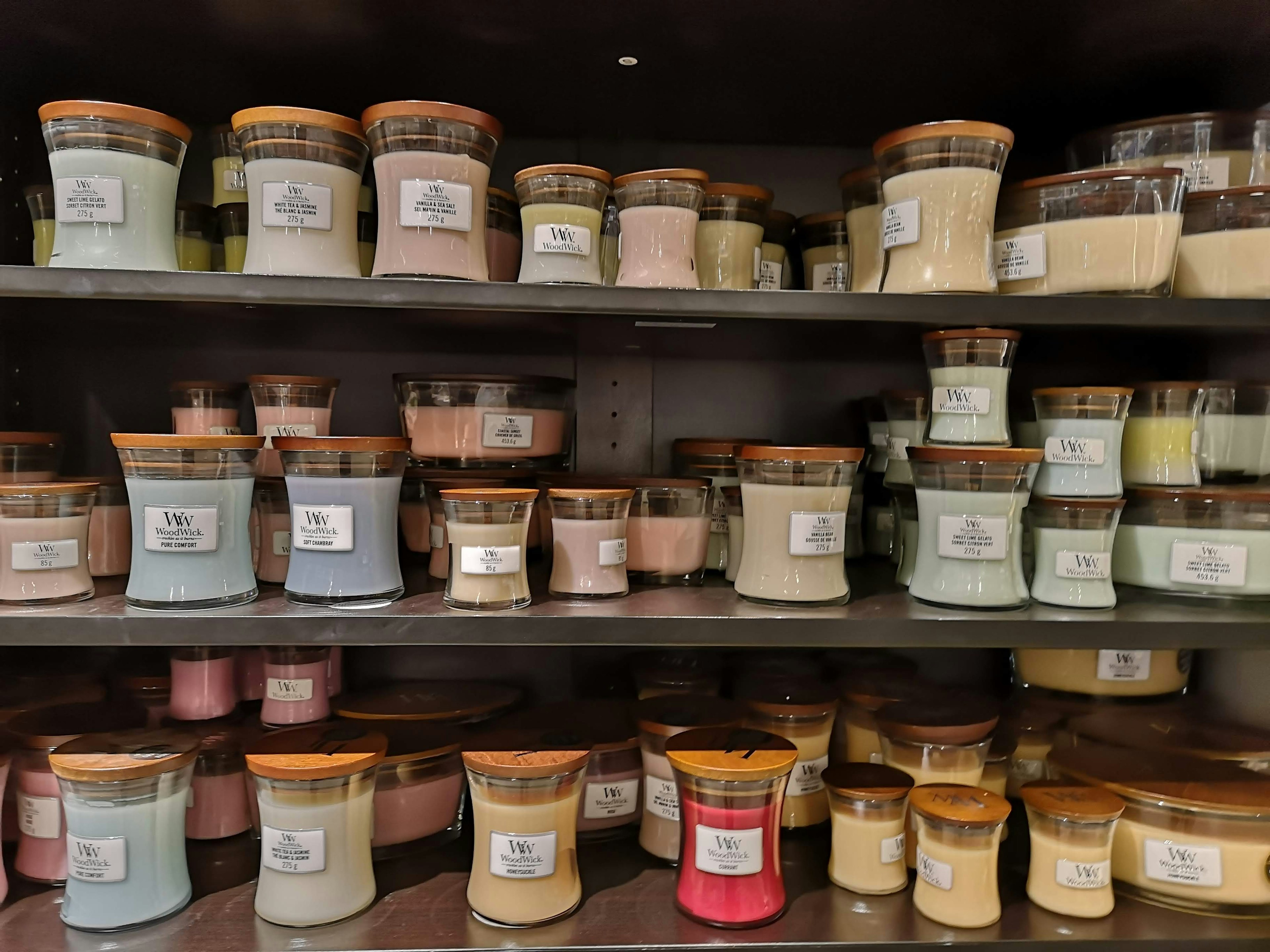 Image of a shelf filled with colorful candles in jars