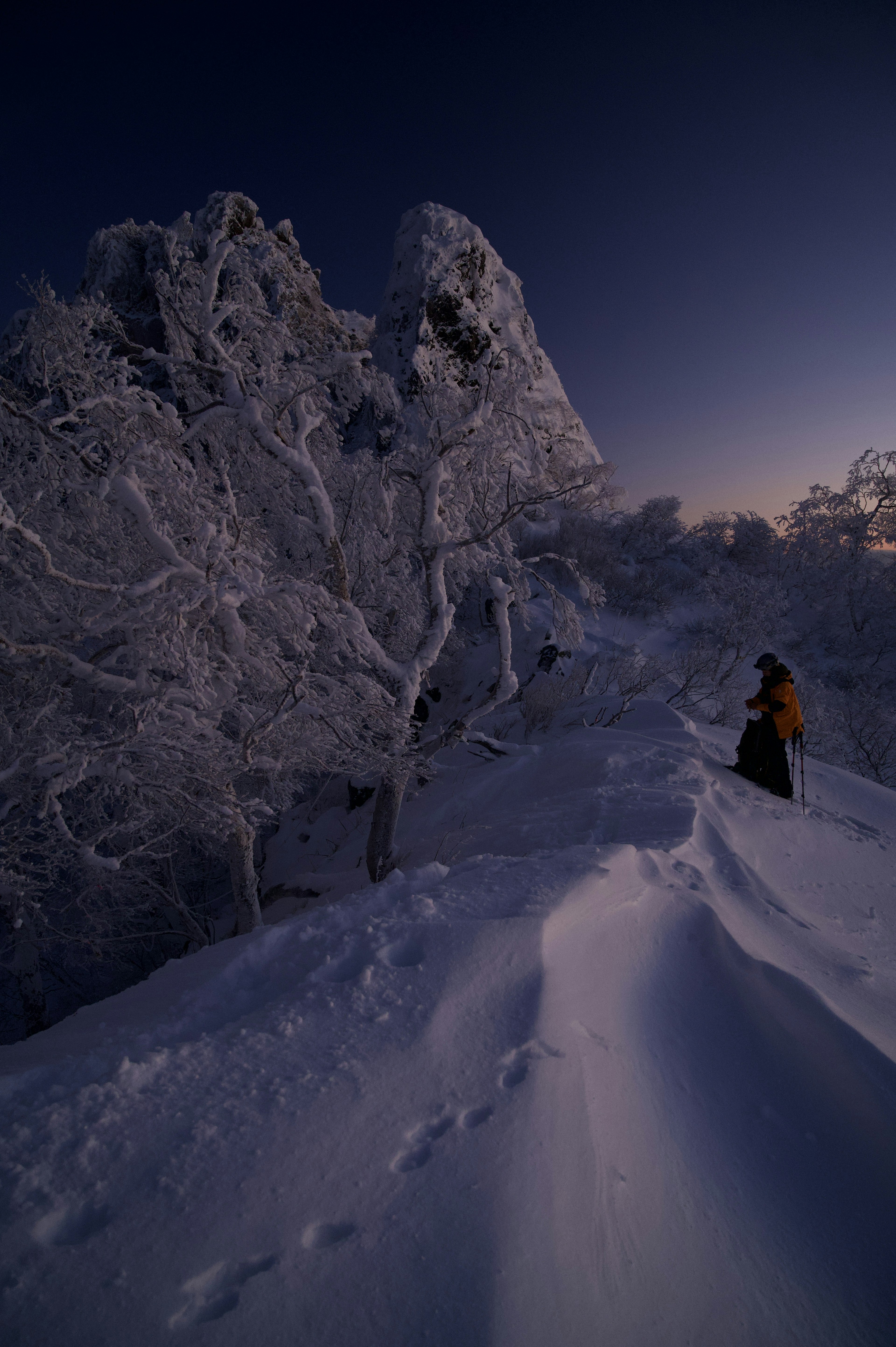 Magnifique coucher de soleil d'hiver avec la silhouette d'une personne et un paysage enneigé