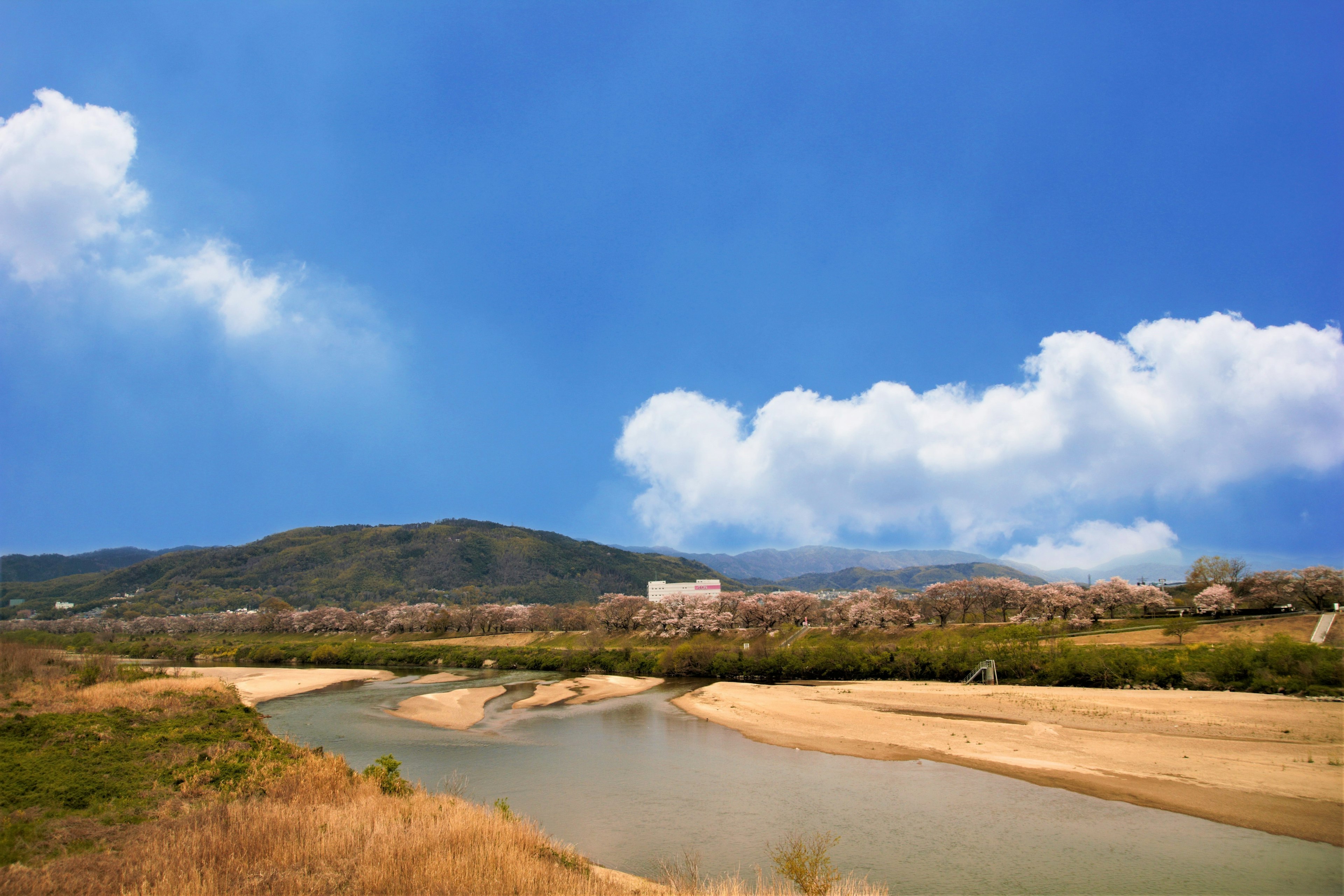 Vista escénica de un río con cielo azul claro pradera seca y colinas distantes