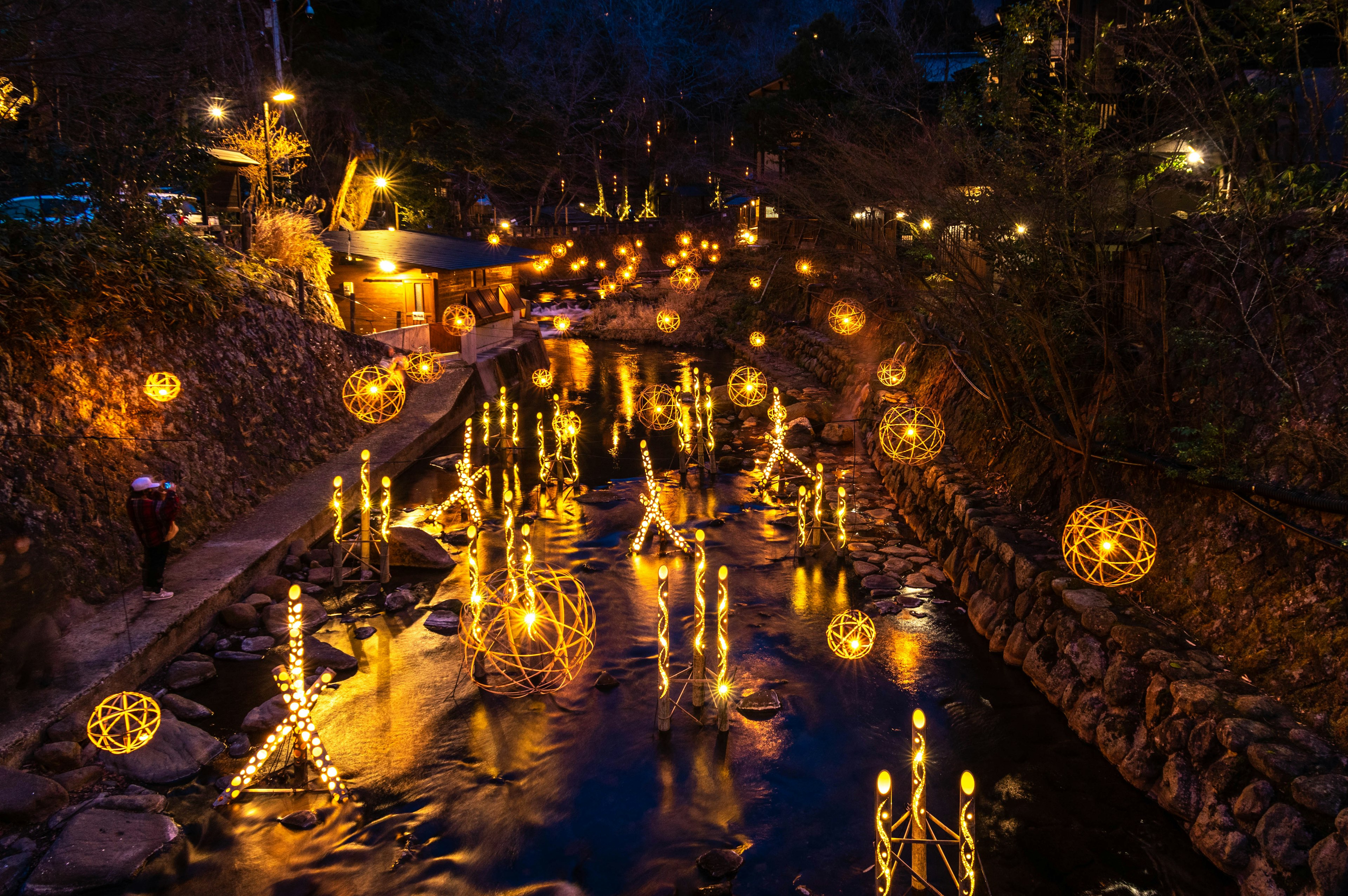 Magical illuminated objects floating on a river at night creating a romantic atmosphere