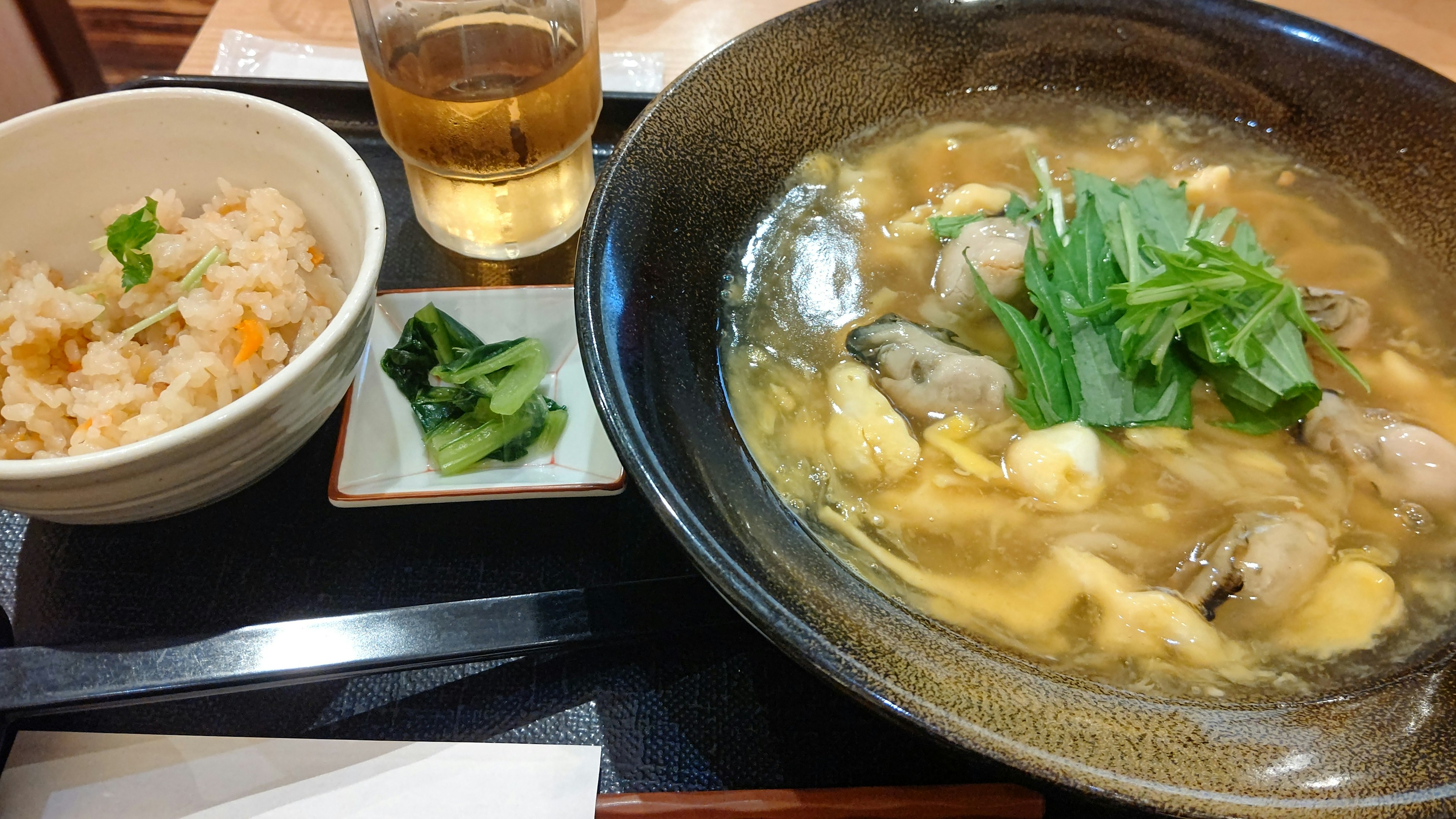 Seafood hot pot with rice a glass of drink and garnished with green vegetables