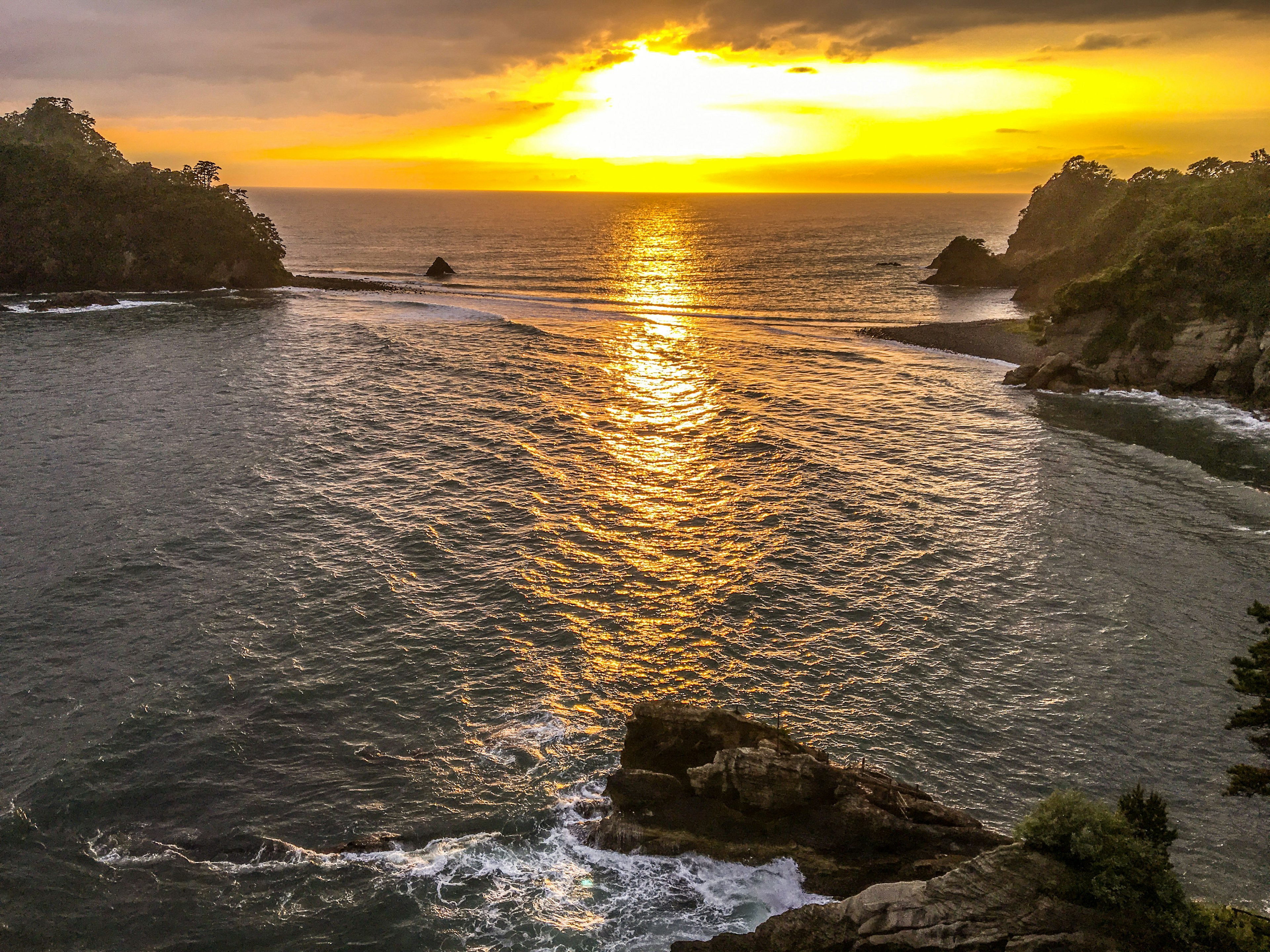 Vue magnifique du coucher de soleil sur l'océan avec des rochers et des vagues