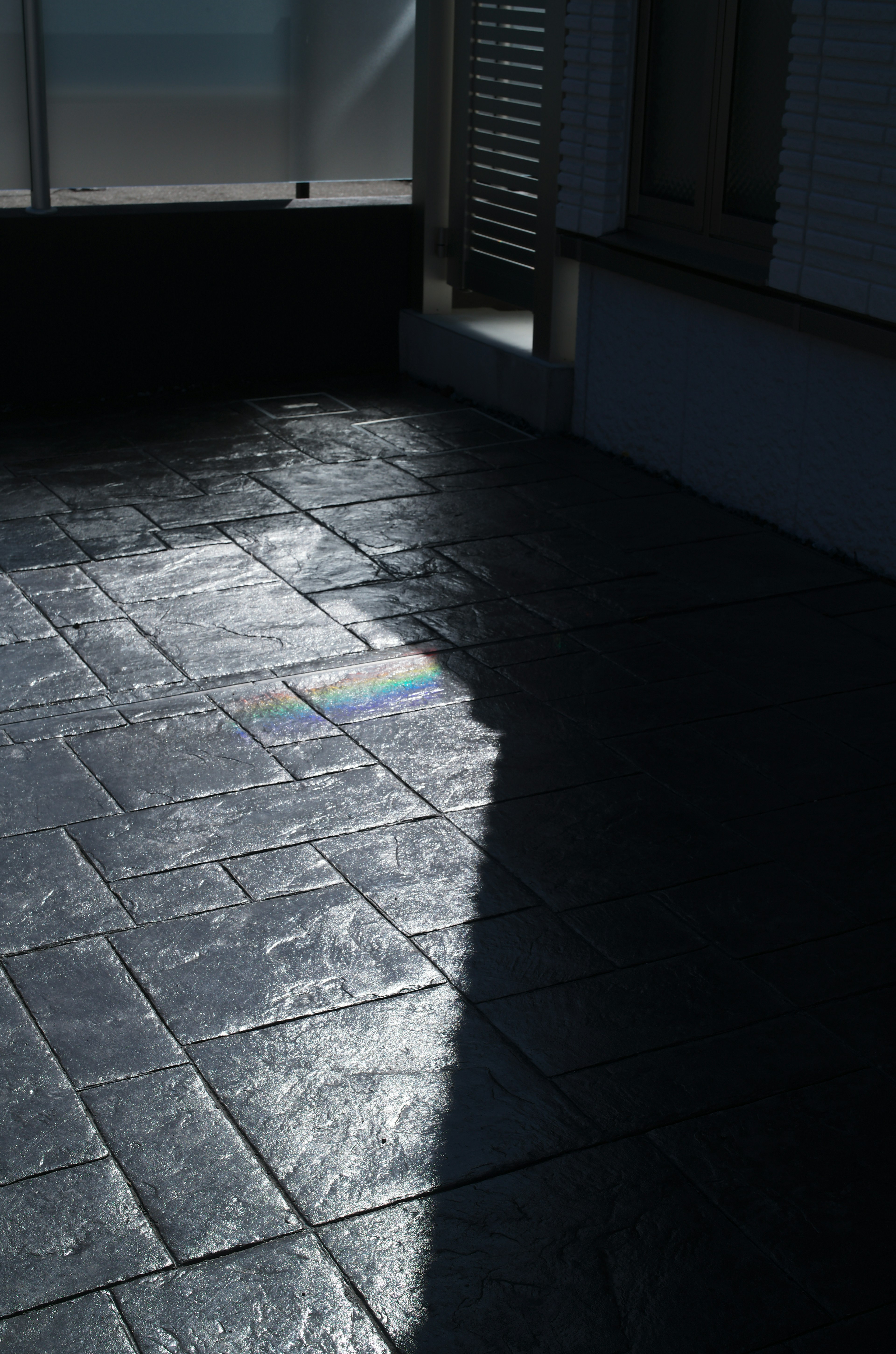 Part of a black stone floor with light reflection