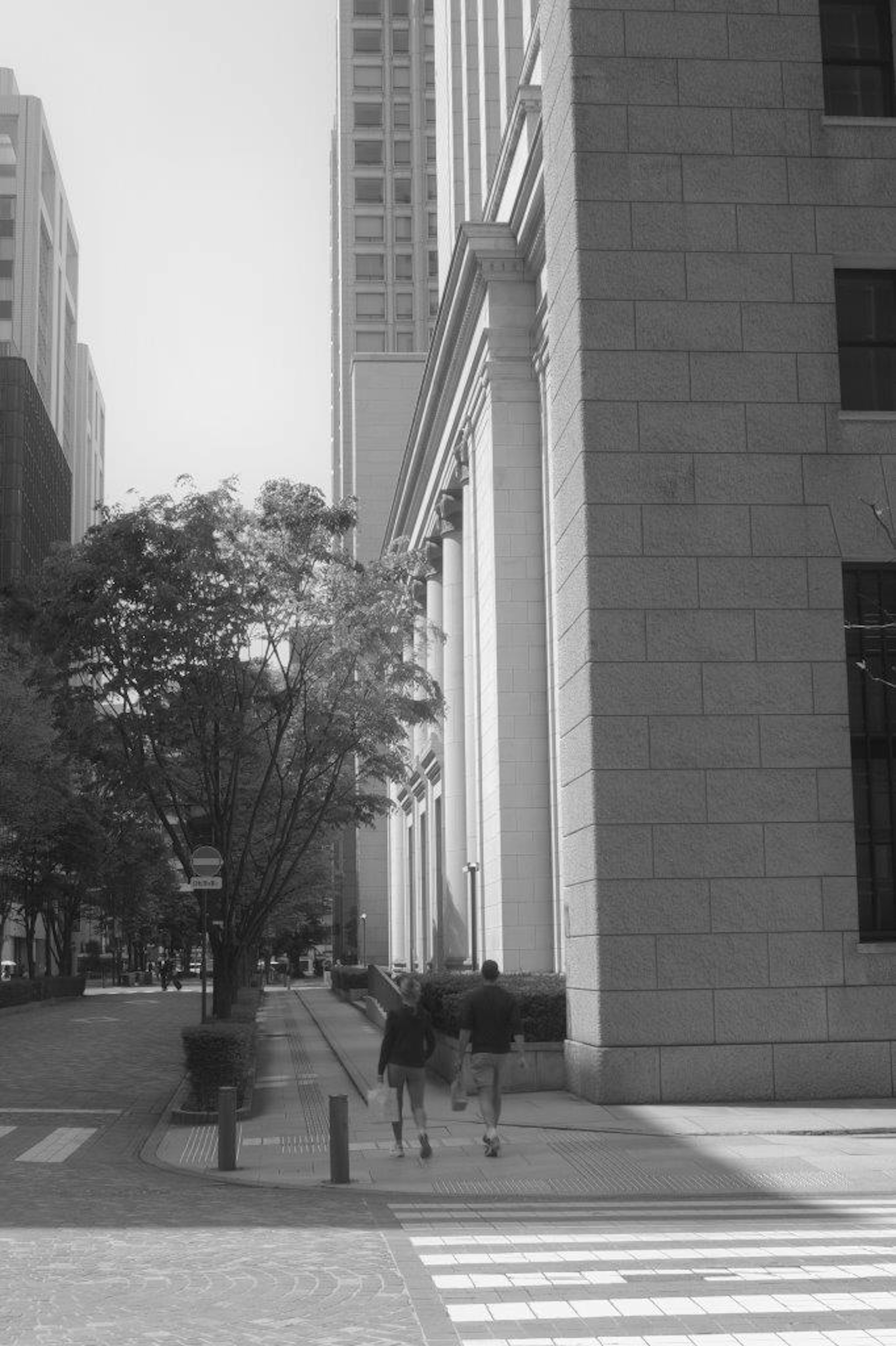 Black and white urban scene featuring pedestrians and tall buildings