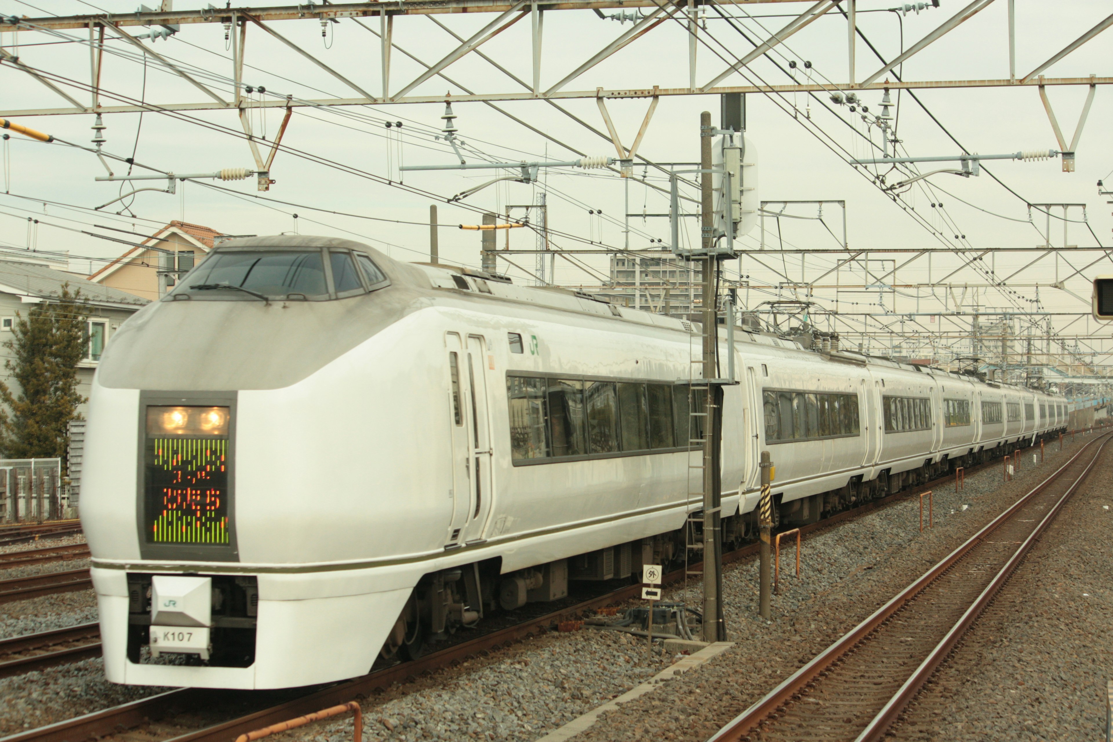 白い特急列車が線路を走行する様子