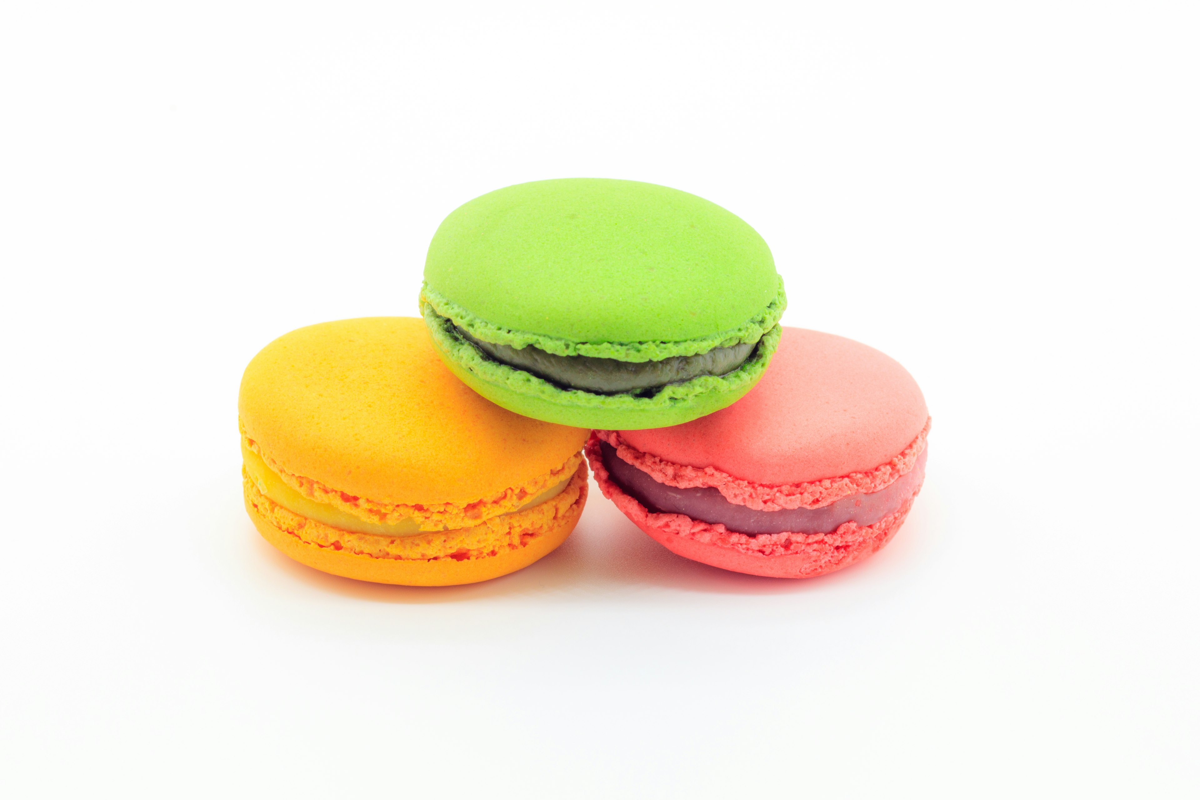 Colorful stack of three macarons in green orange and pink