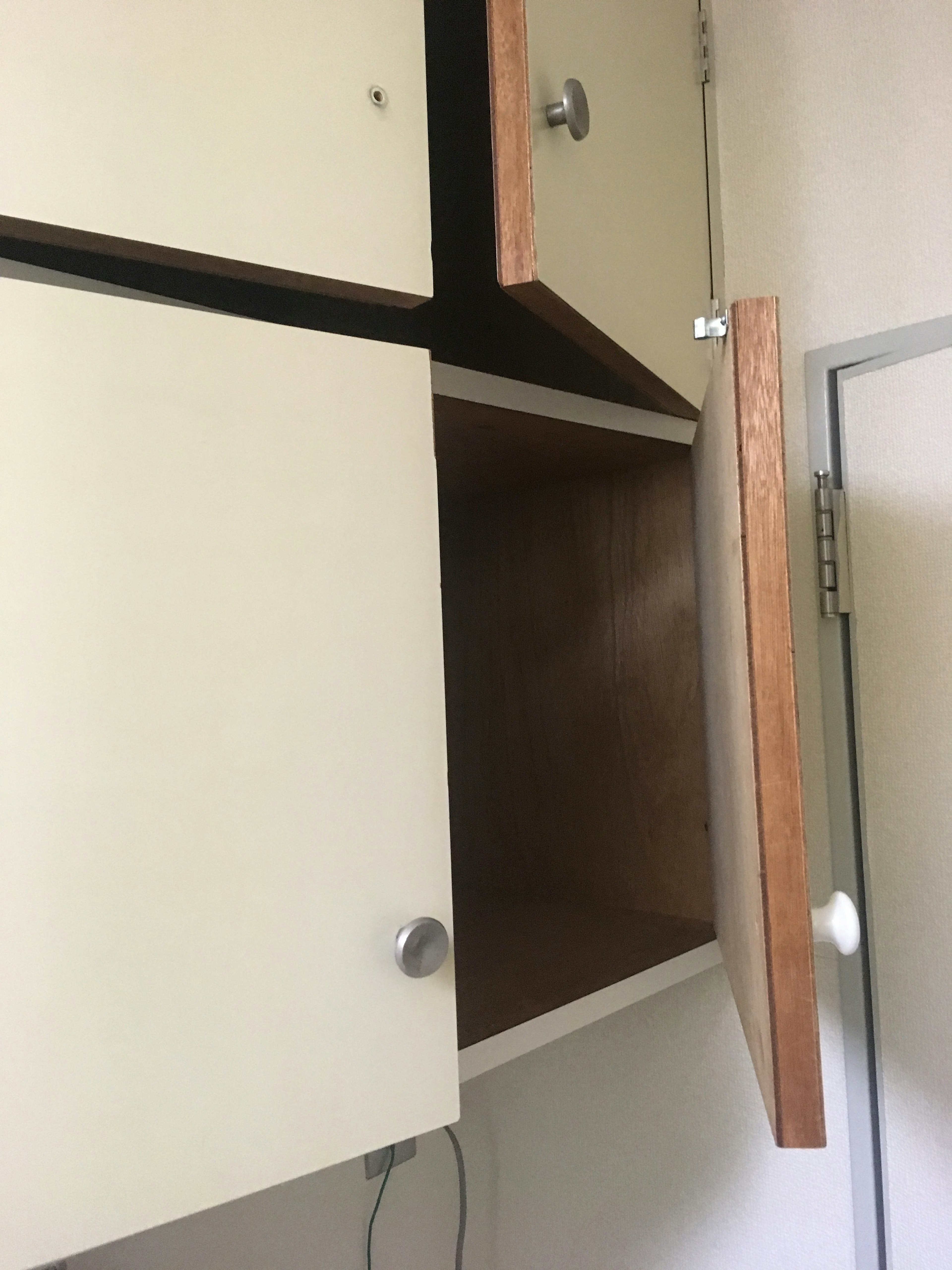 Open cabinet door revealing wooden interior