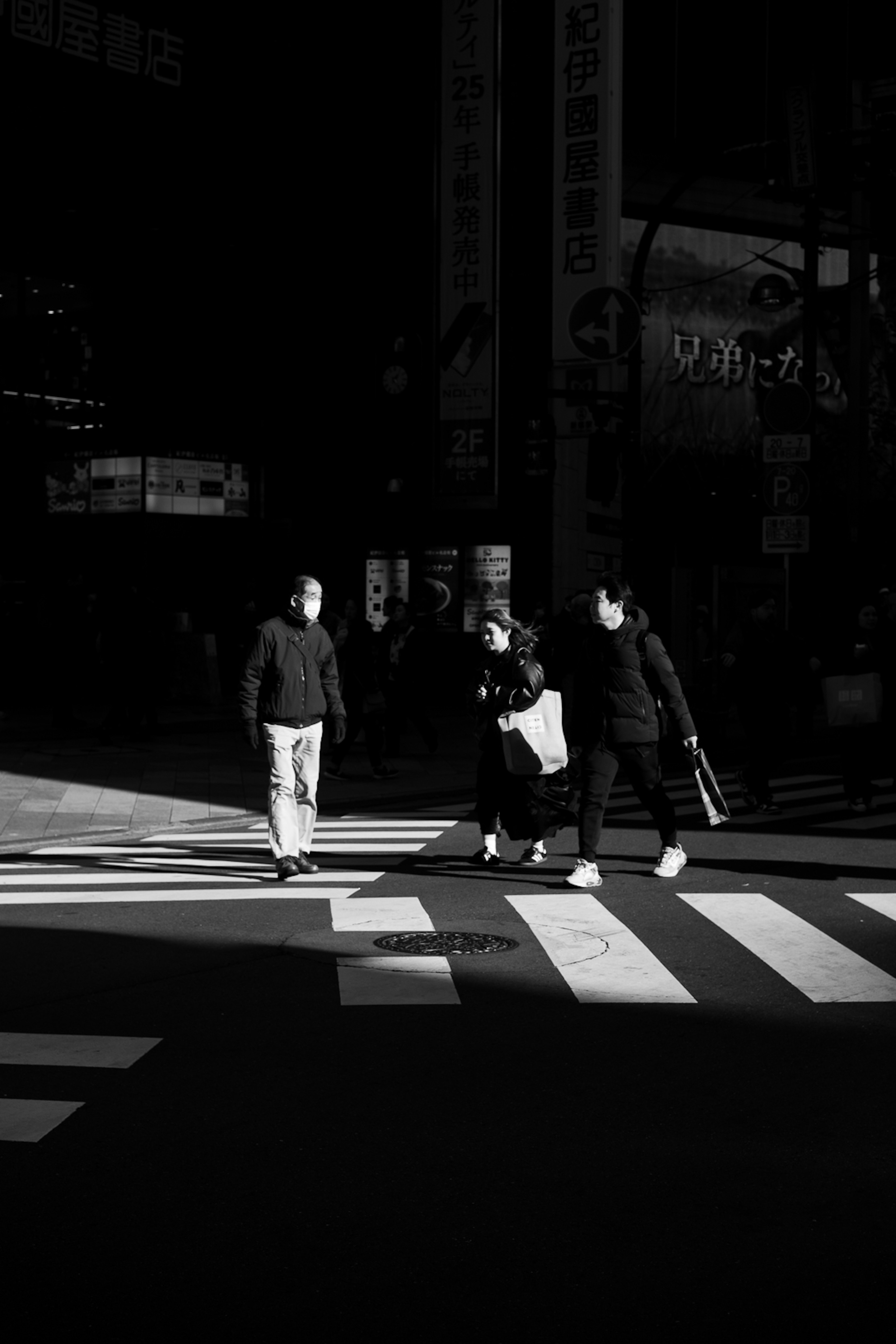 暗い背景の中で横断歩道を渡る人々のシルエット