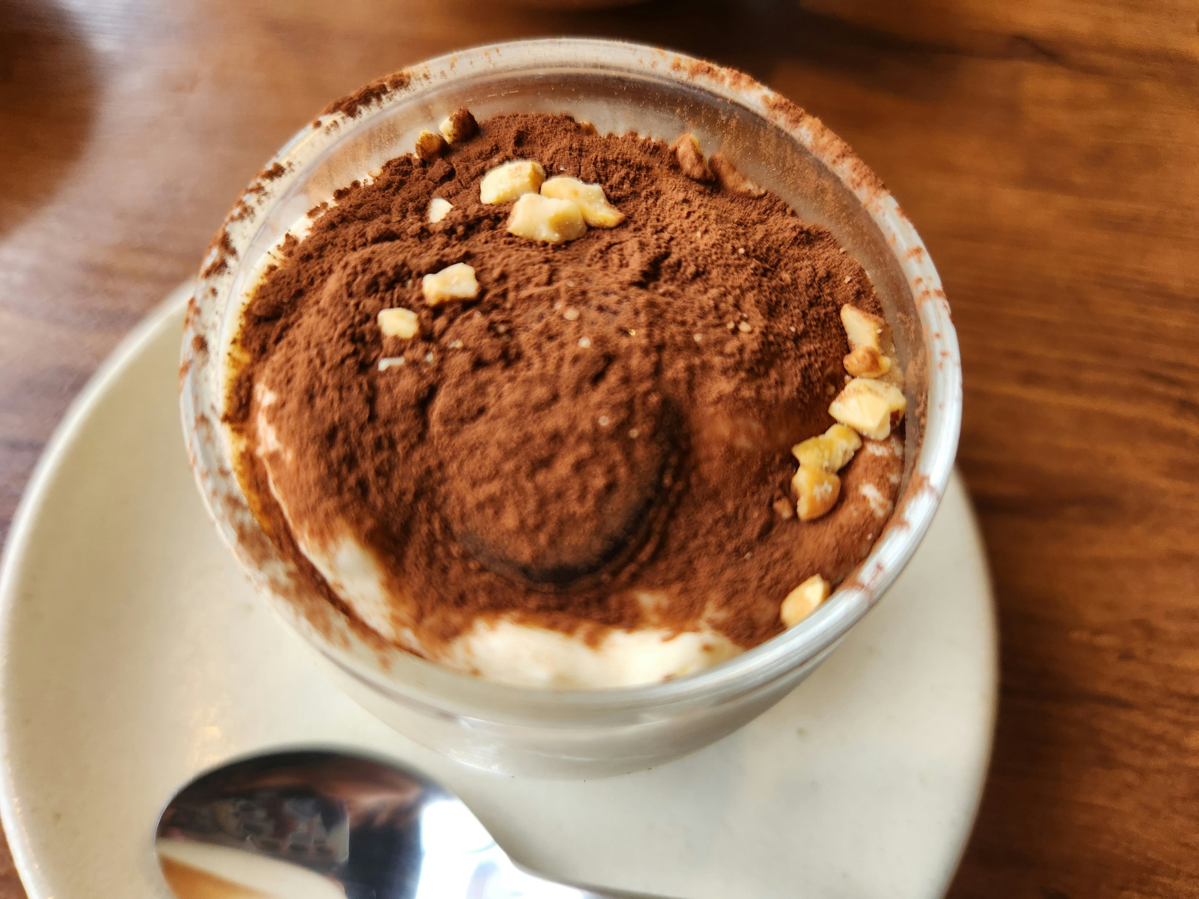 Creamy tiramisu dessert cup topped with cocoa powder and nuts