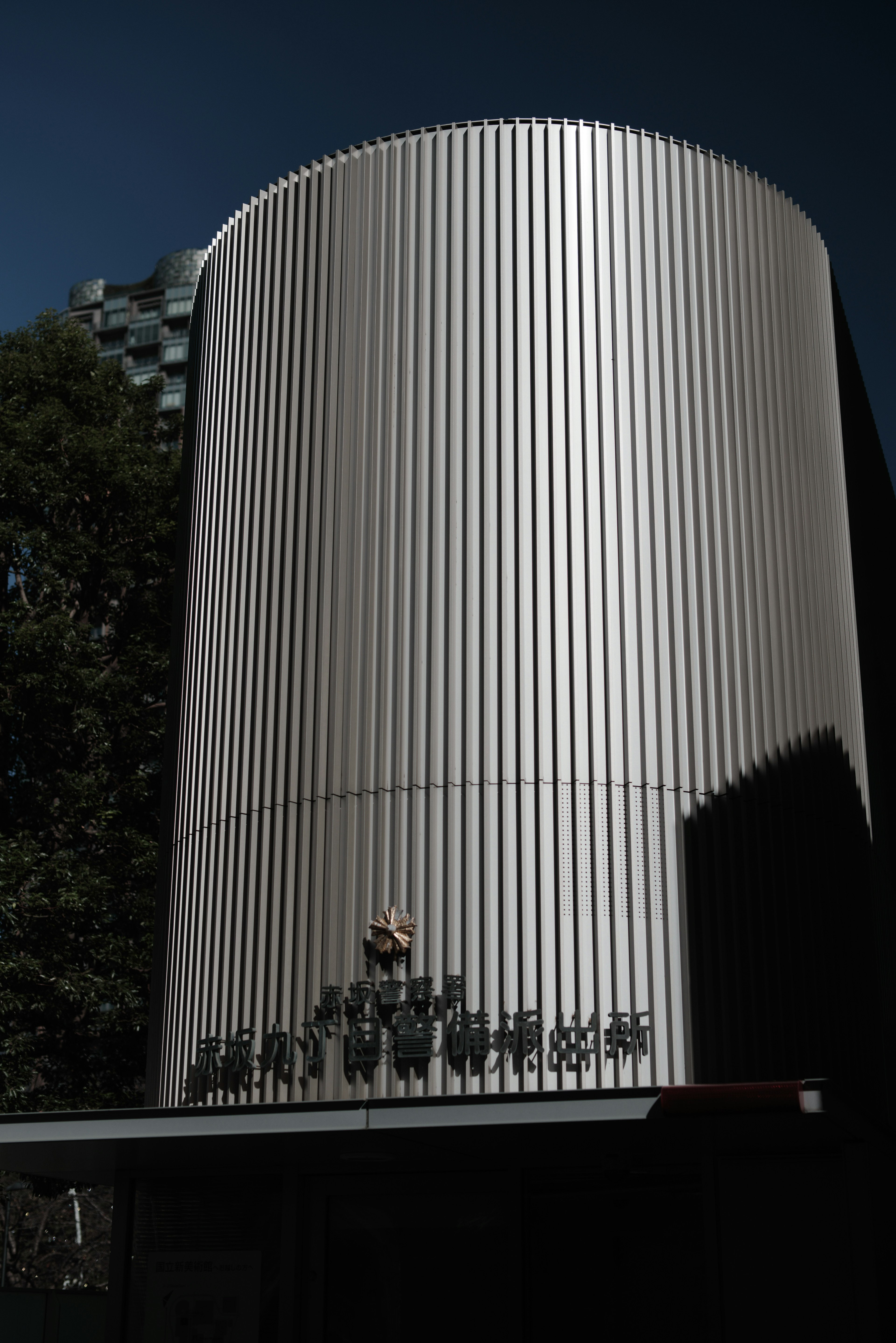 Silver cylindrical building with a person standing in front