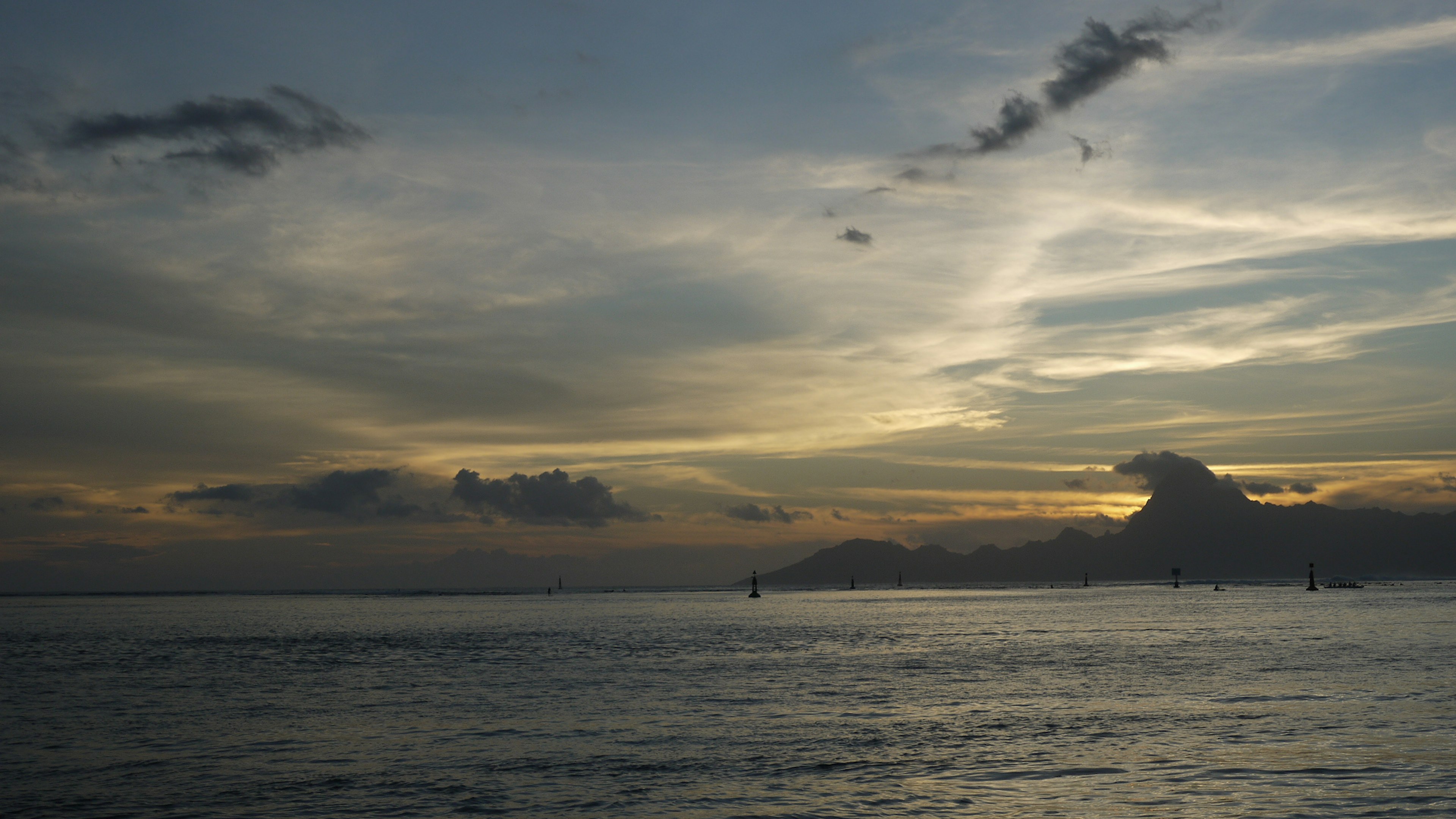 Vista escénica de un atardecer sobre el océano con nubes y olas tranquilas