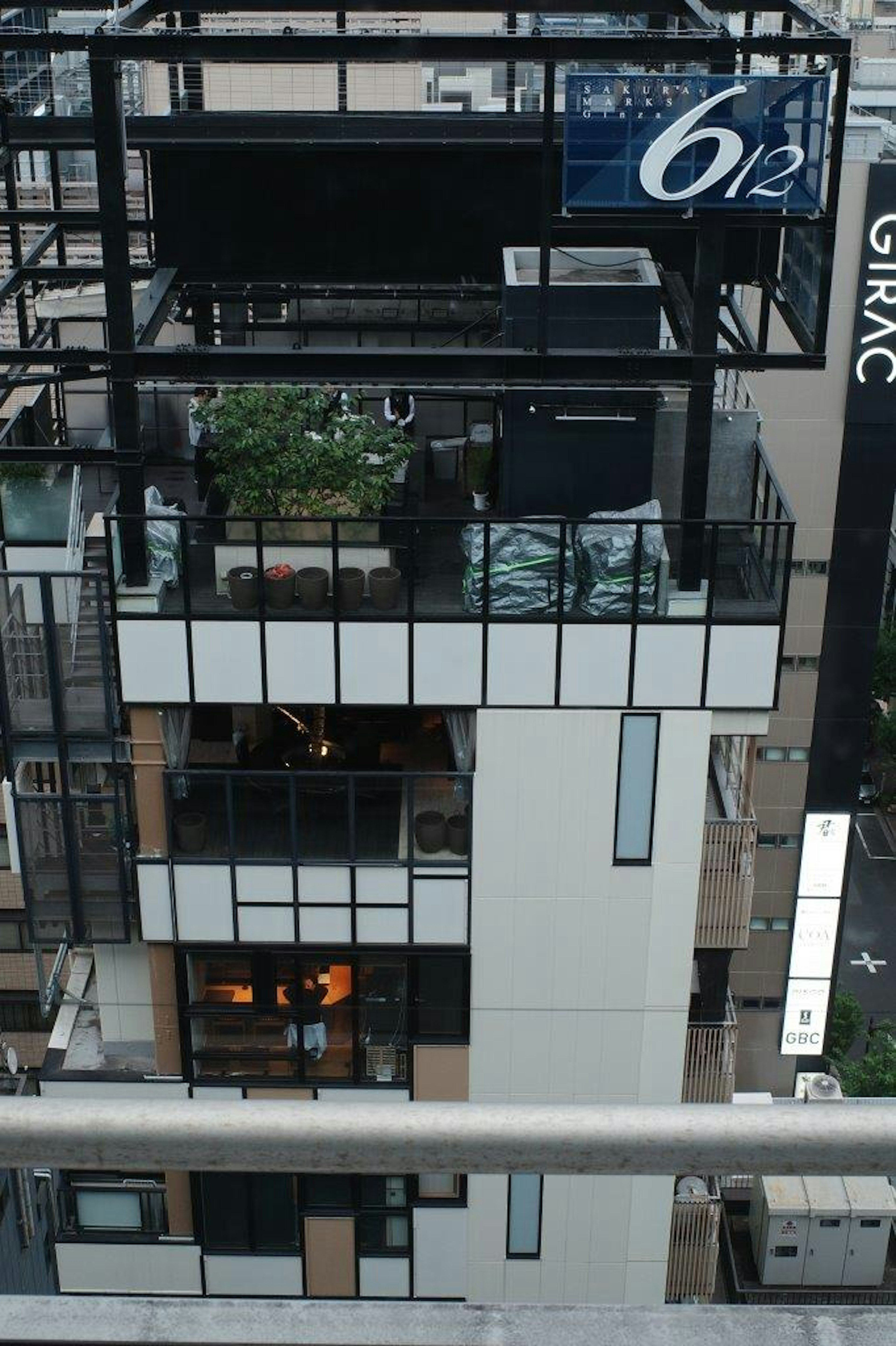 Un extérieur de bâtiment moderne avec un balcon avec des plantes et de grandes fenêtres