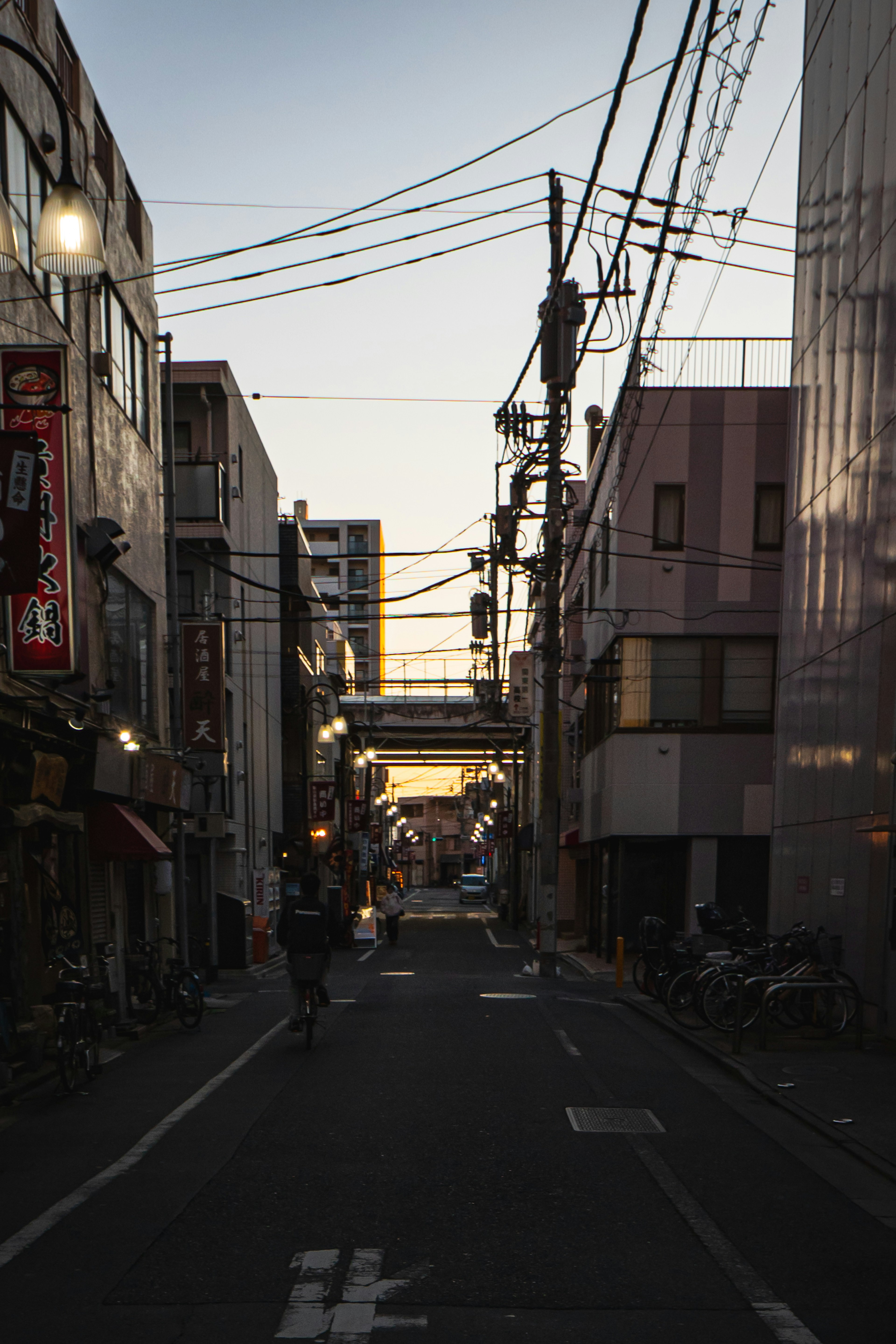 夕暮れ時の都市の通りに沿った建物と電線