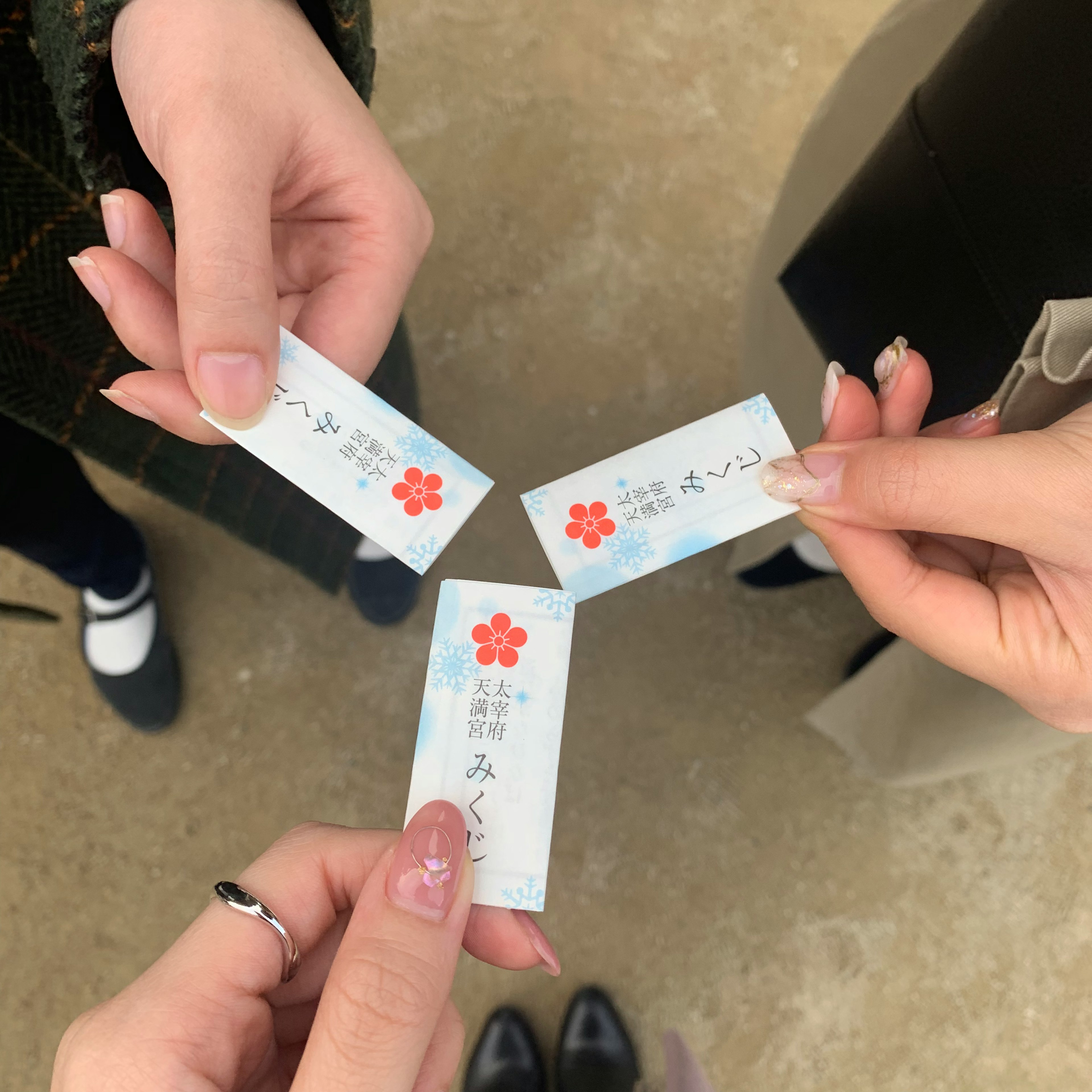 Three small cards held in hands featuring a cherry blossom design