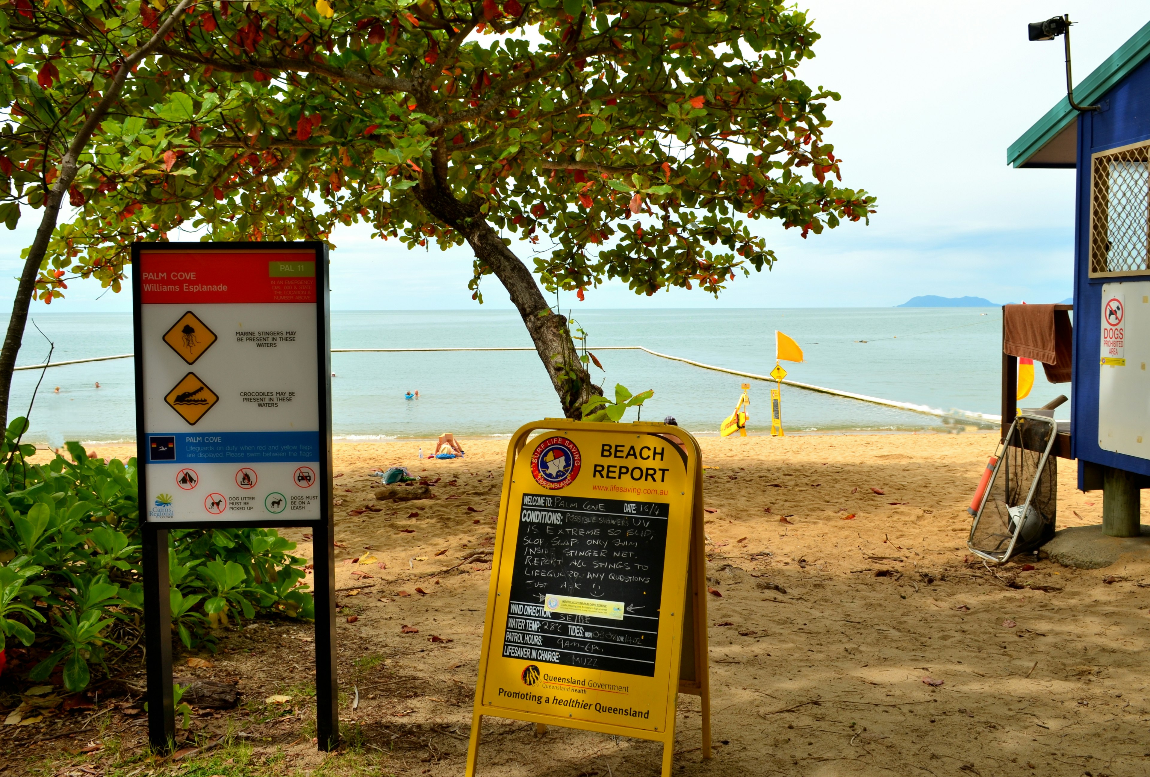 Pintu masuk pantai dengan tanda peringatan keselamatan dan papan informasi