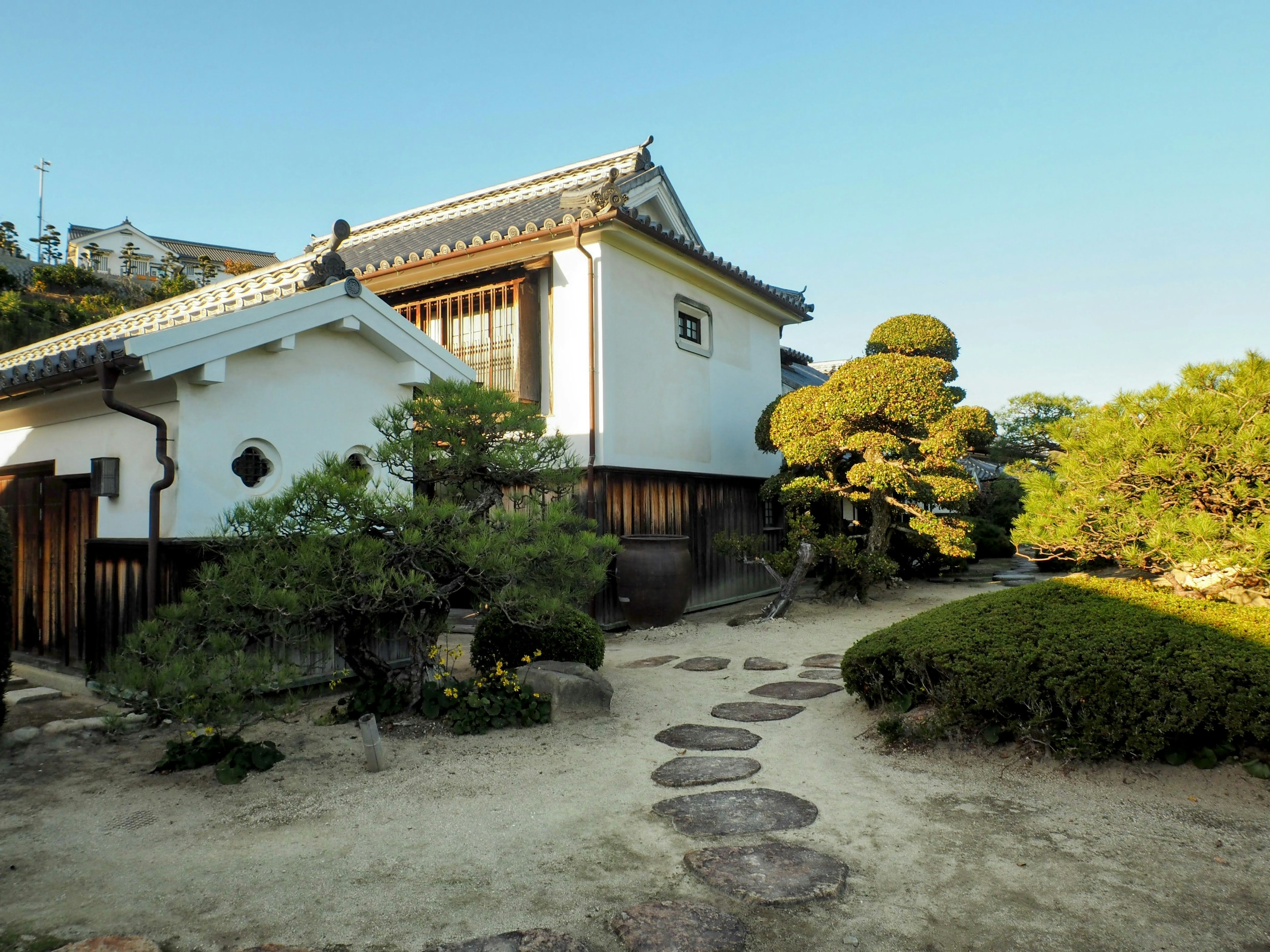 Rumah Jepang tradisional putih dengan taman yang terawat baik