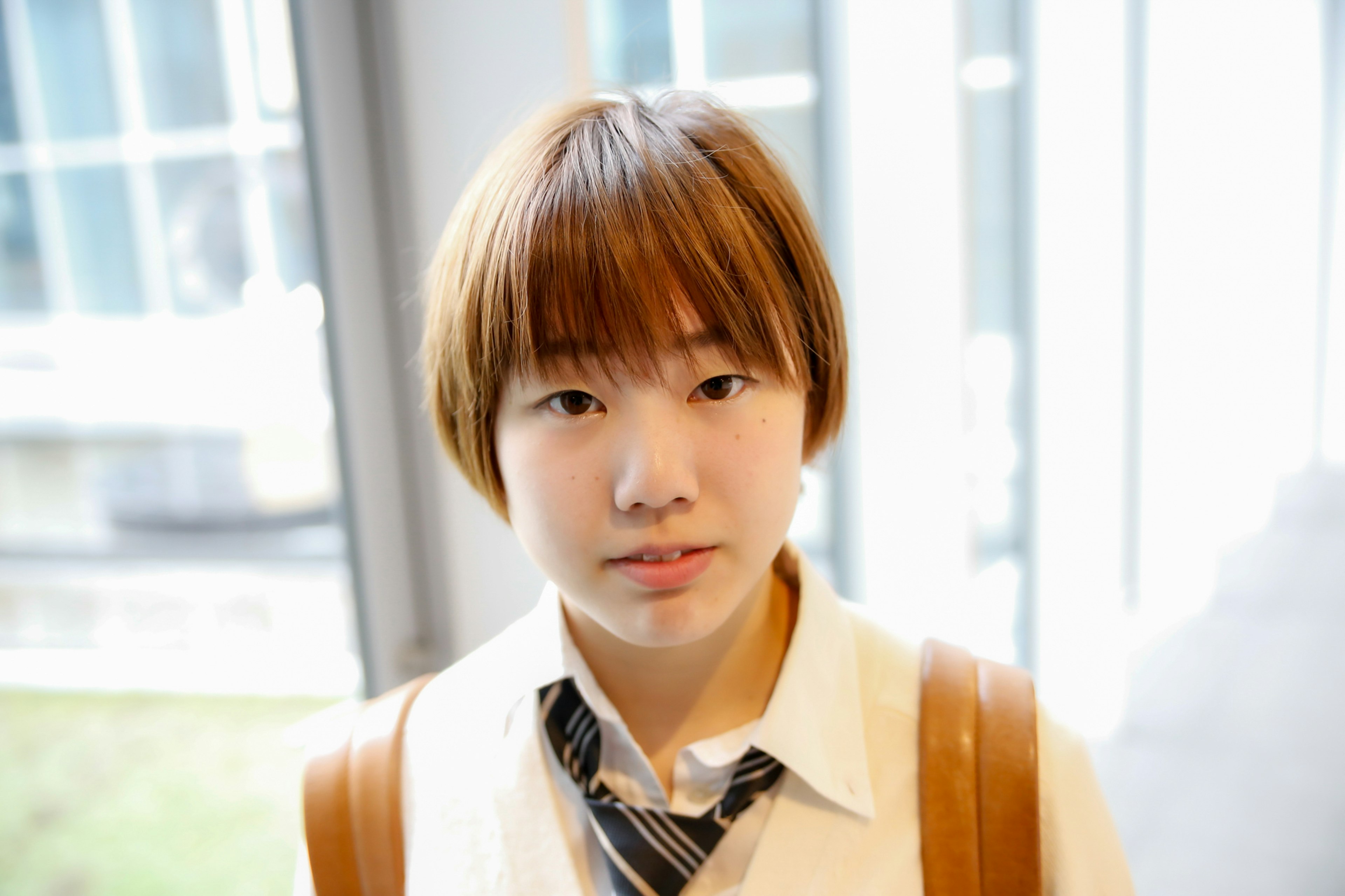 Jeune femme avec une coiffure distinctive portant une chemise blanche et une cravate