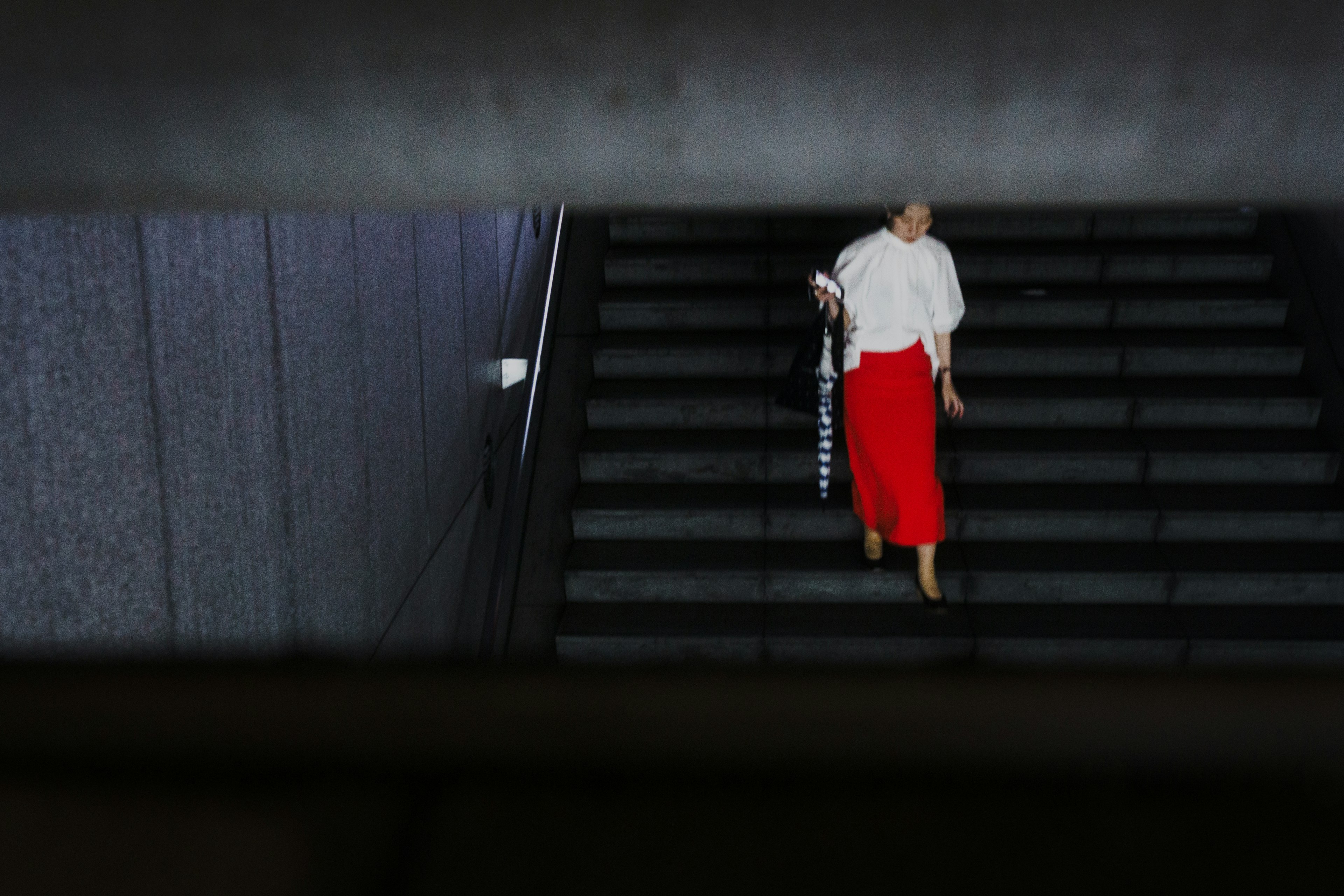 A woman in a red skirt walking down stairs