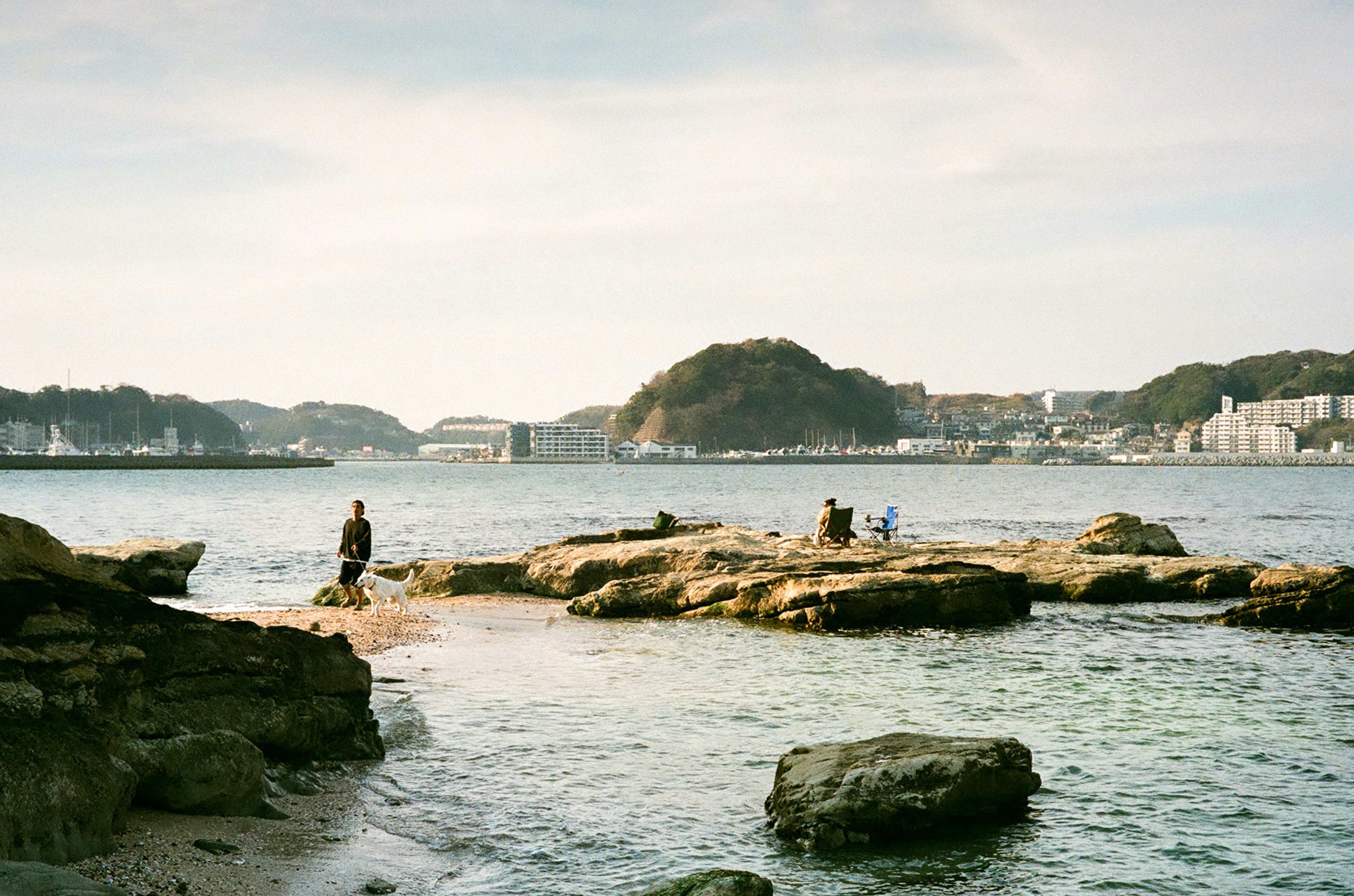 People enjoying the rocky coastline with a serene sea view