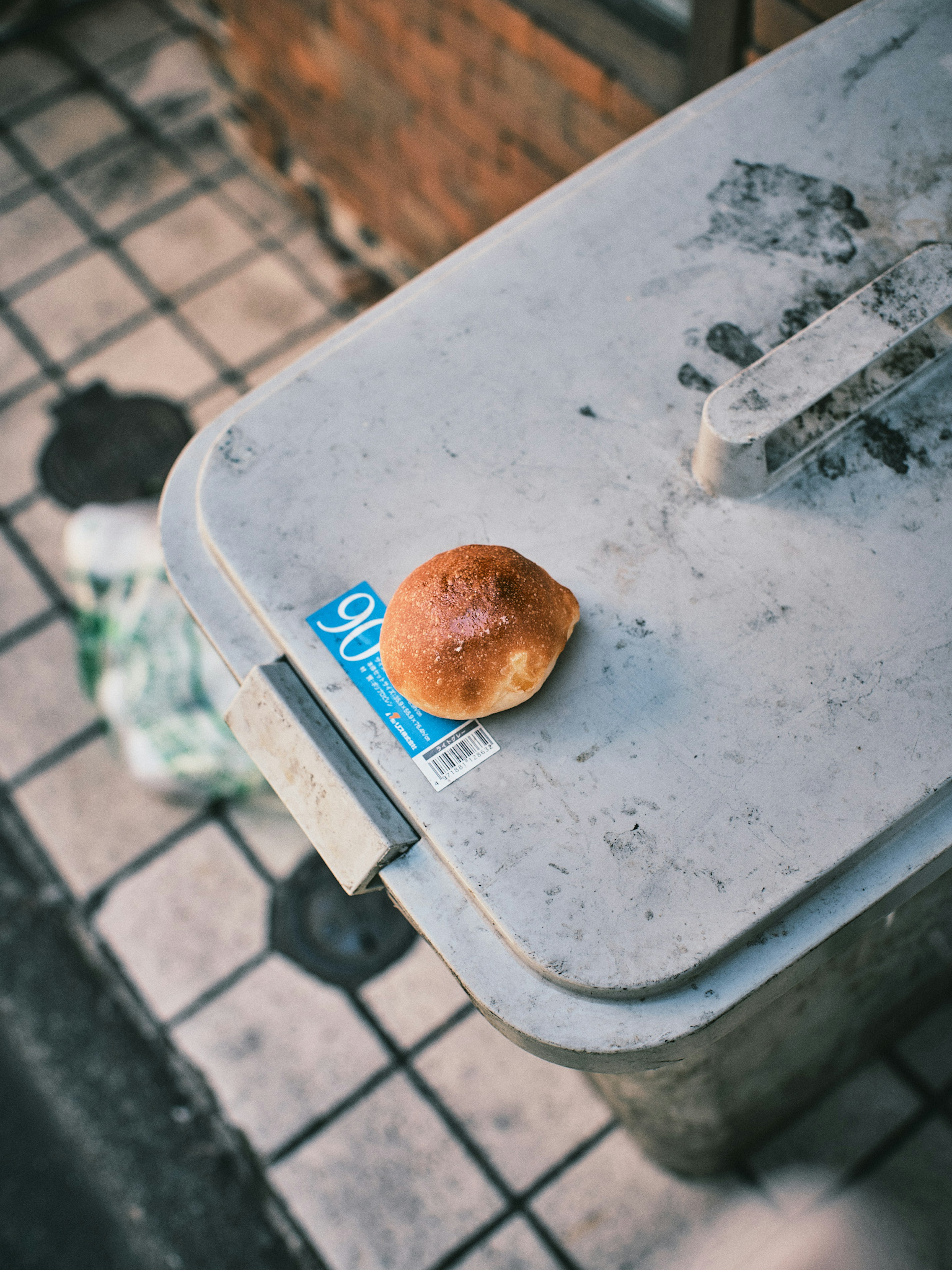 Un panino posato su un bidone della spazzatura