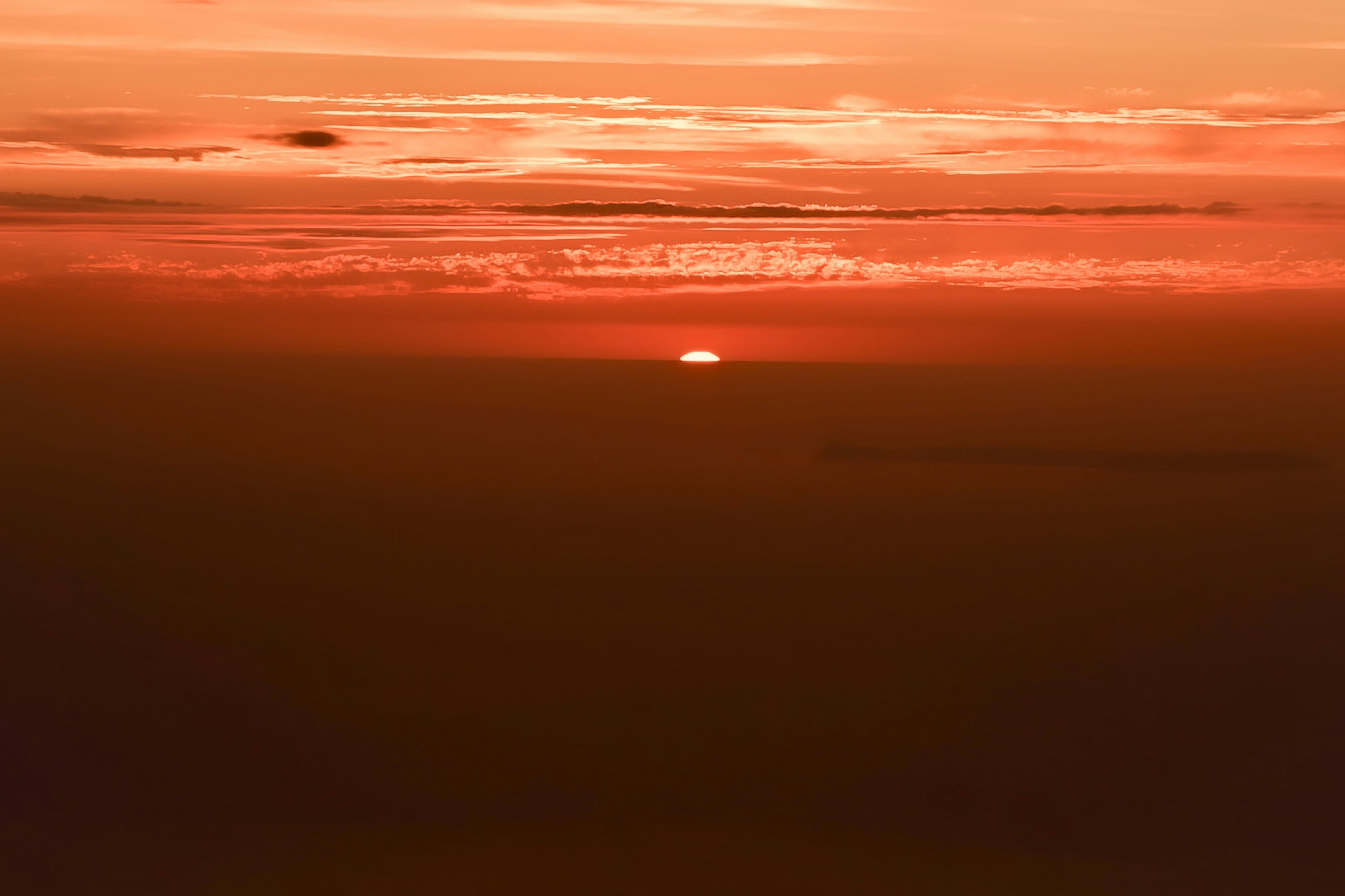 夕日のオレンジ色のグラデーションと穏やかな雲