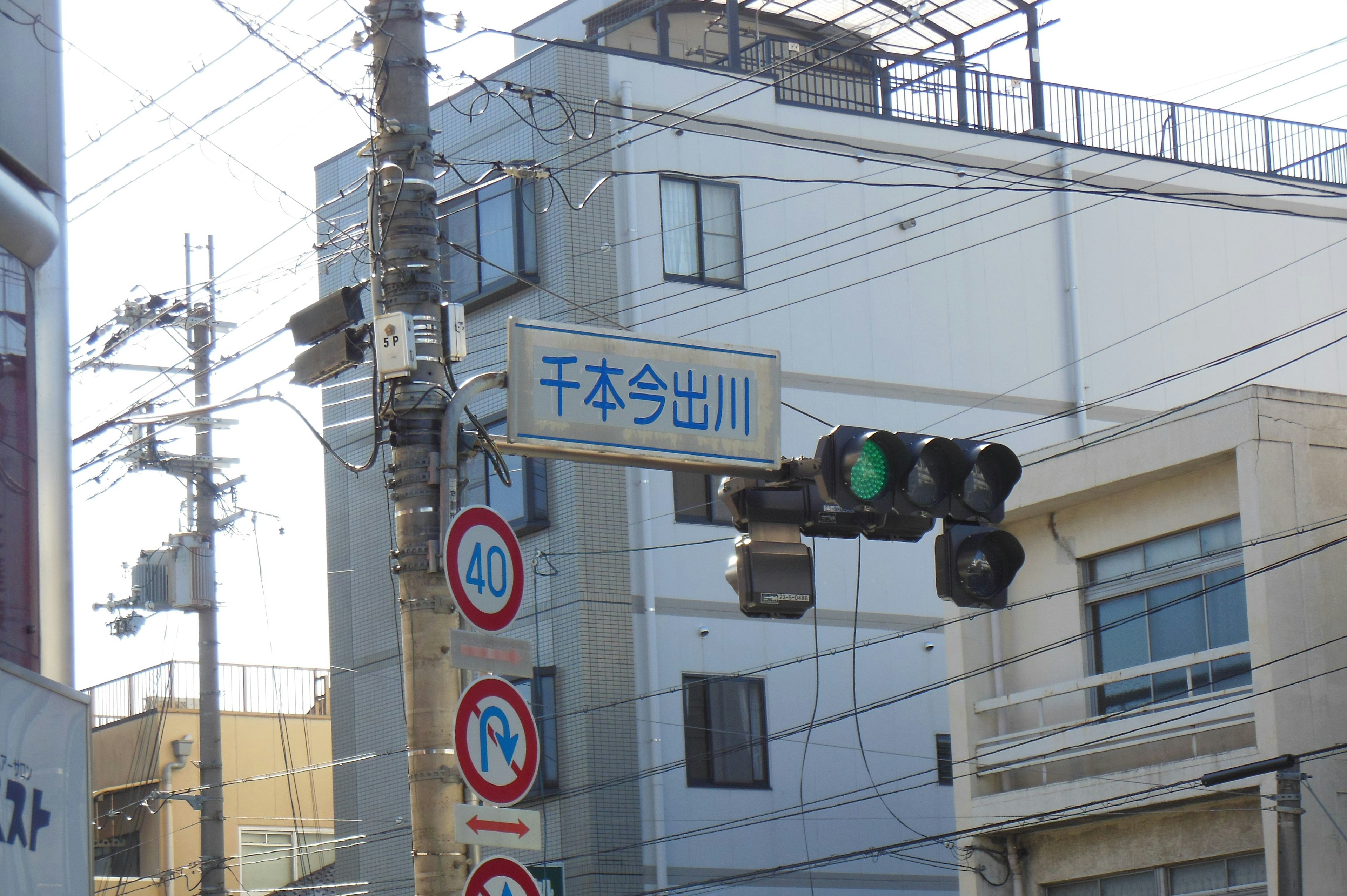 Urban scene featuring a green traffic light and street signs