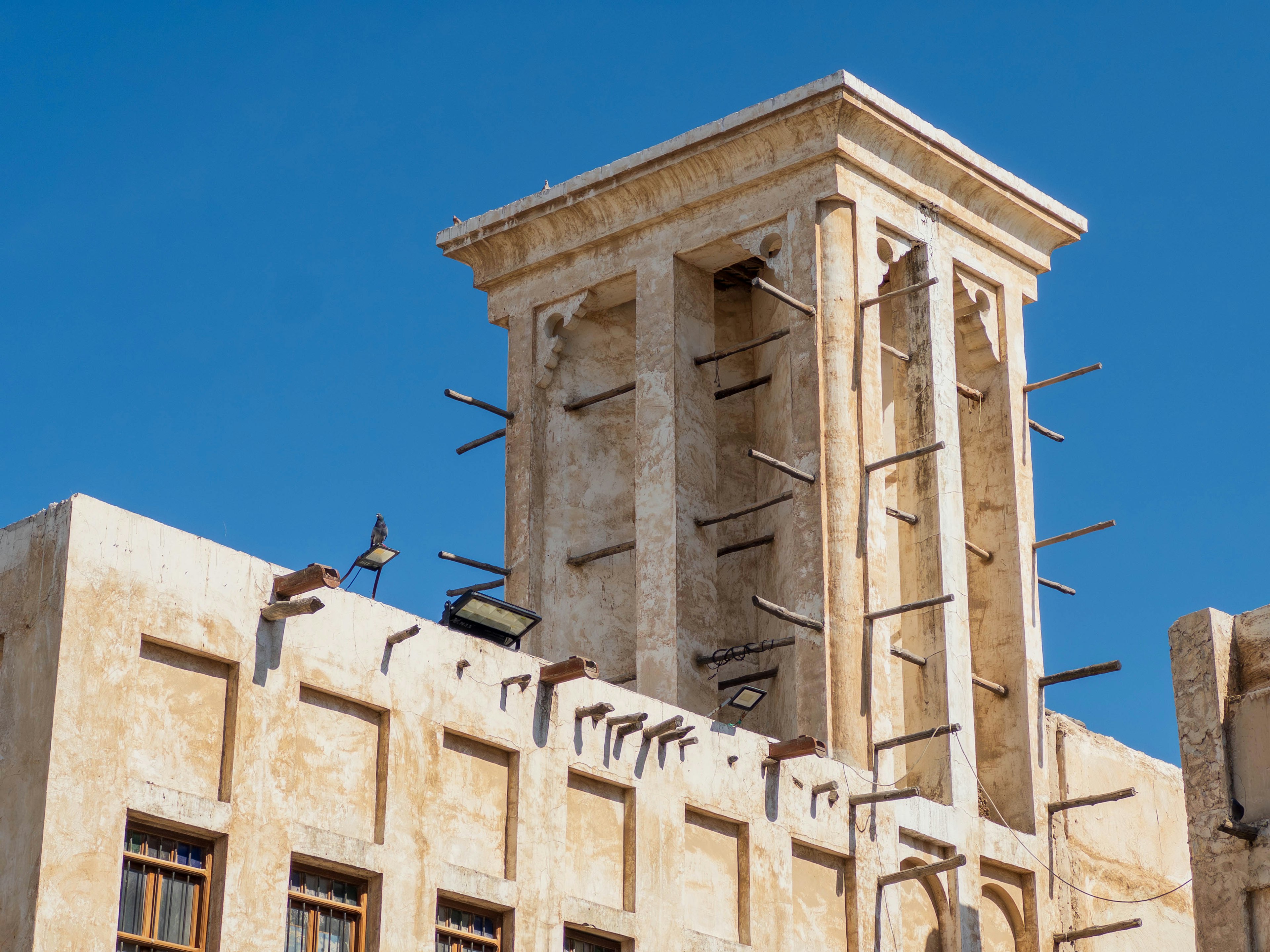 Traditioneller Architektur-Turm unter einem blauen Himmel mit dekorativen Säulen und verglasten Wänden