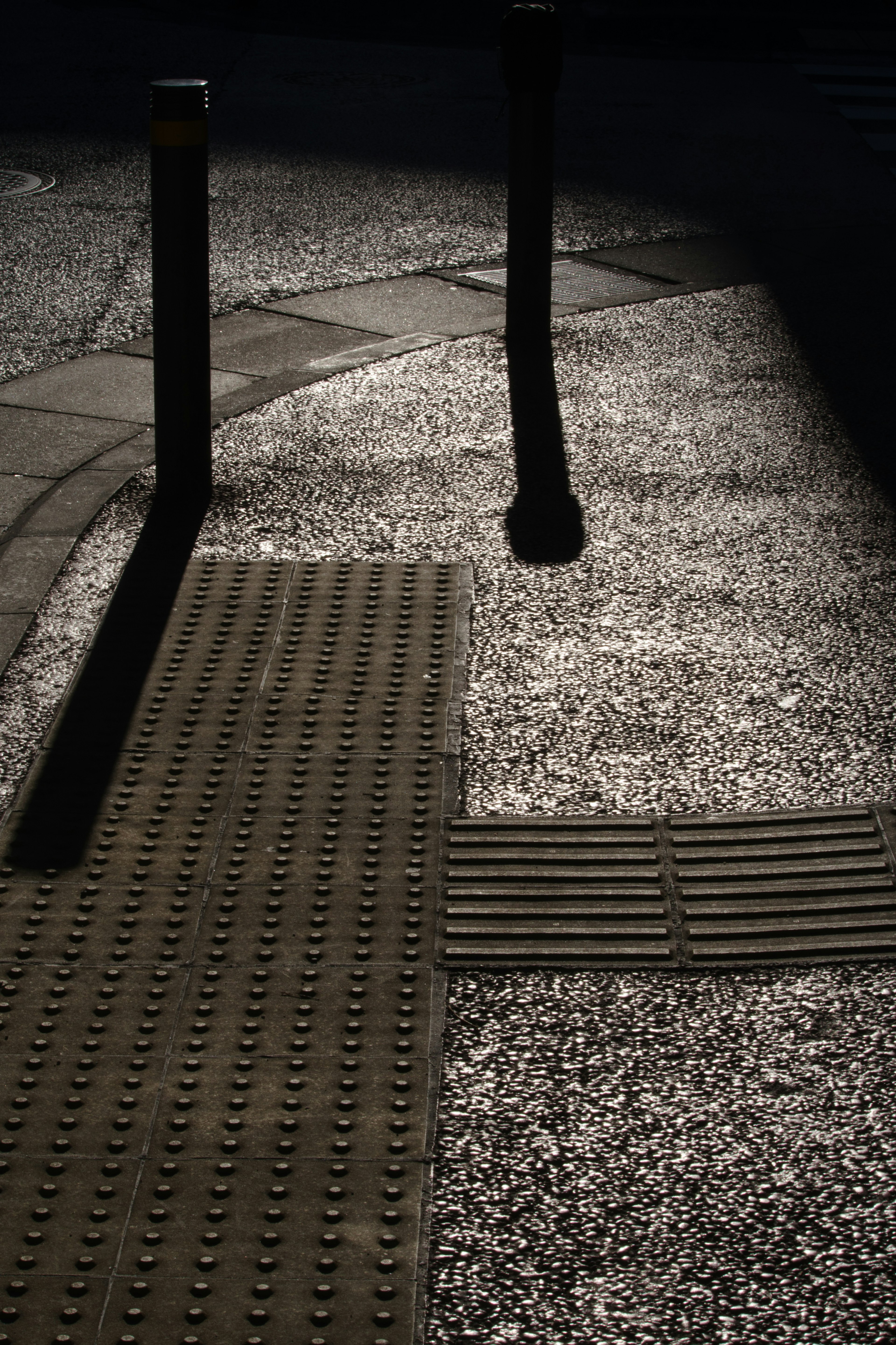 Kontrast zwischen Schatten und Licht auf einem gepflasterten Weg mit strukturierten Oberflächen