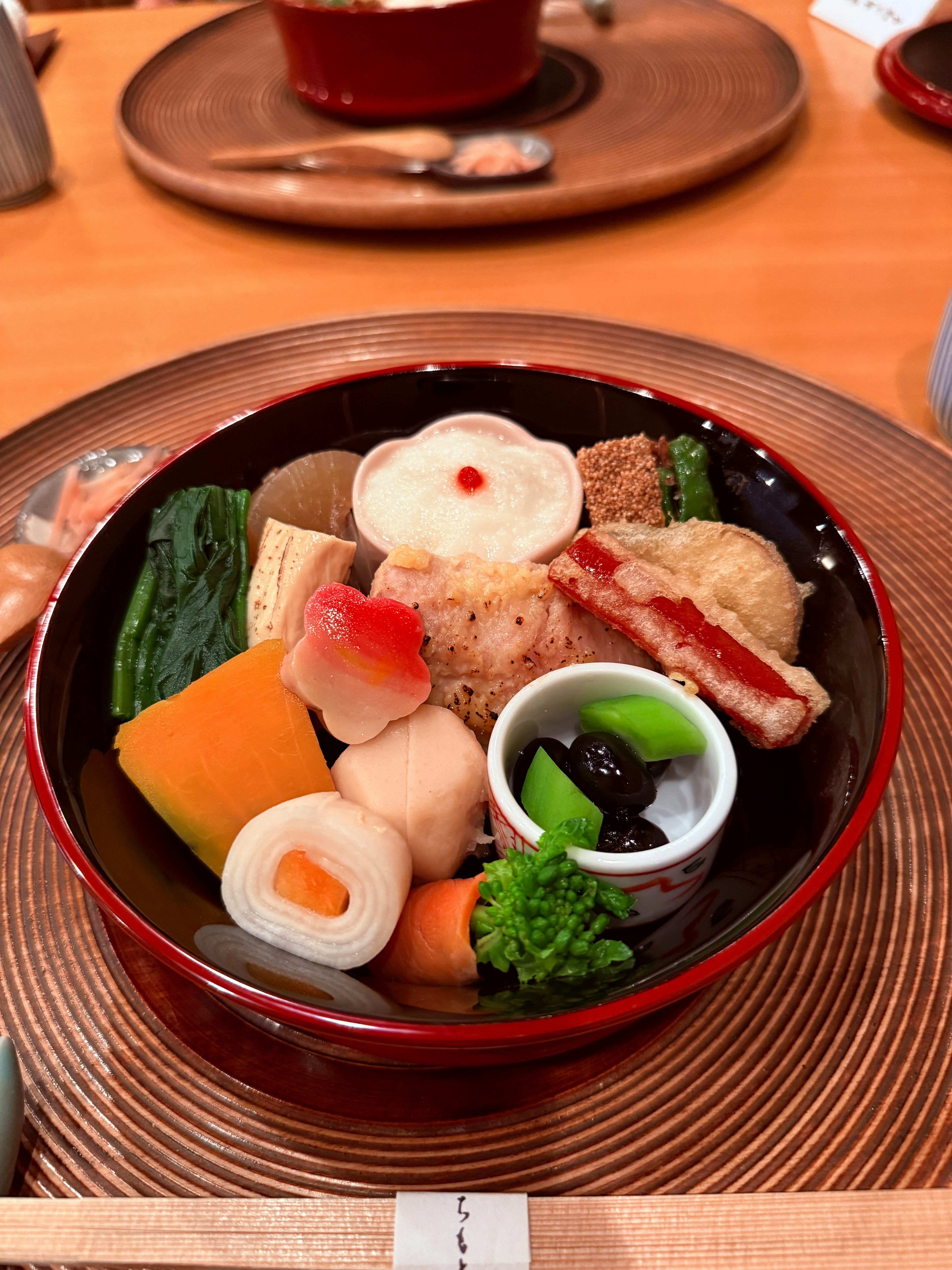 Cocina japonesa colorida y verduras servidas en un tazón rojo