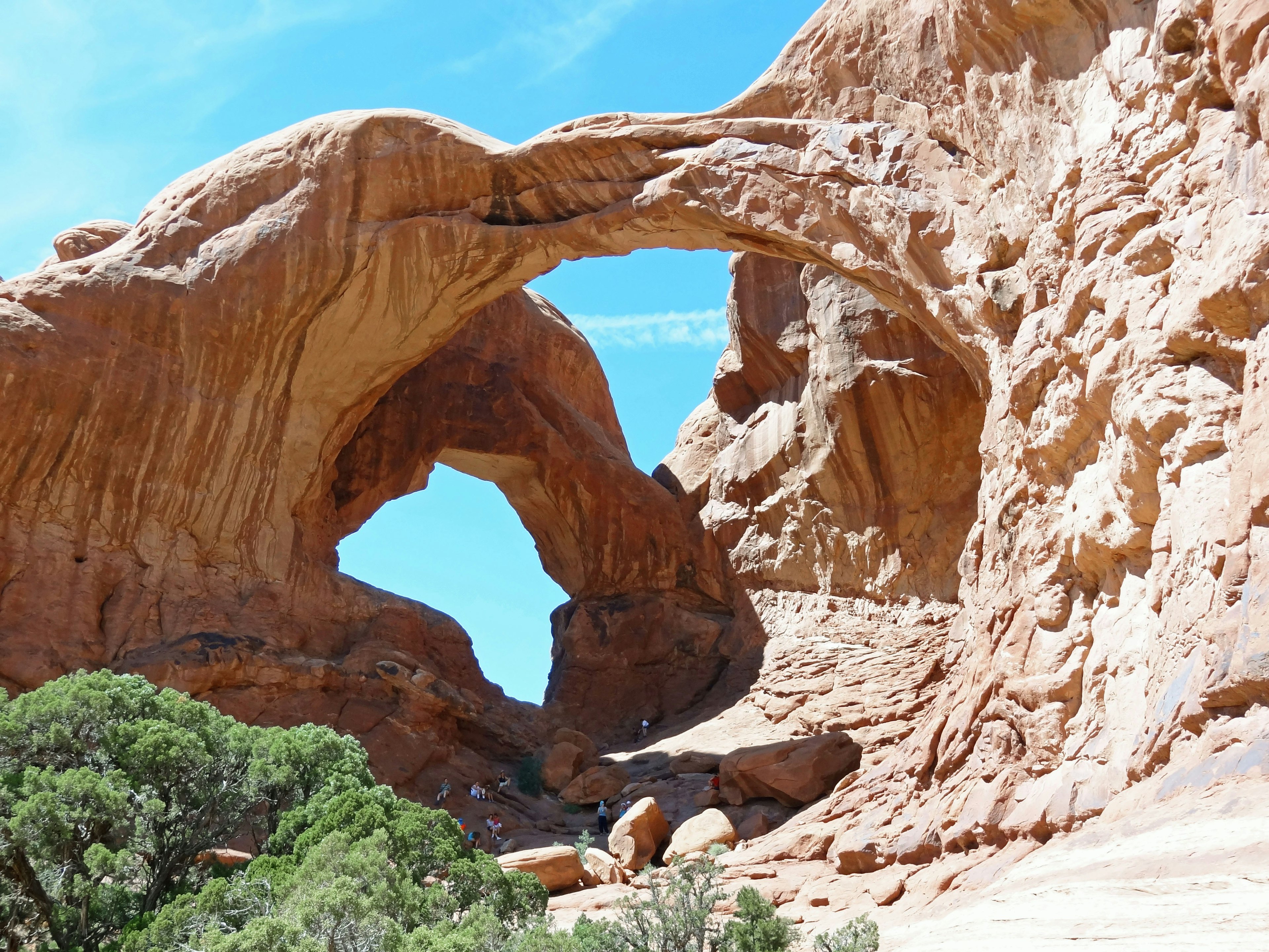 Red rock arches under a clear blue sky