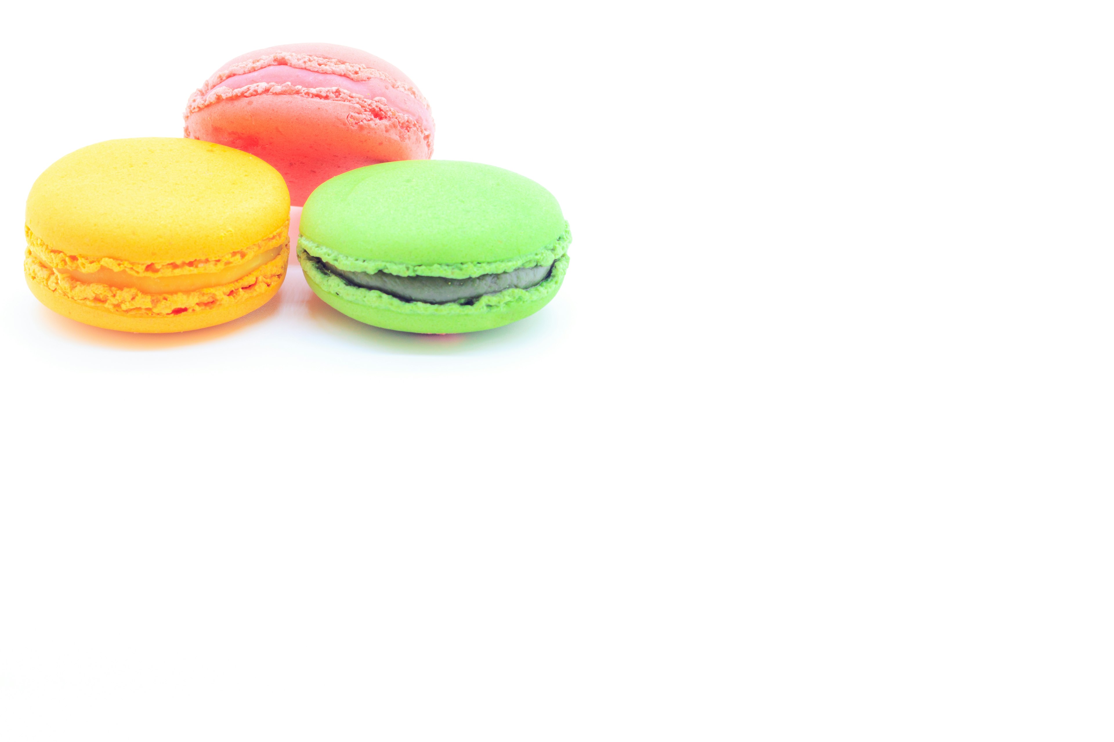 Ensemble coloré de macarons en jaune, vert et rose