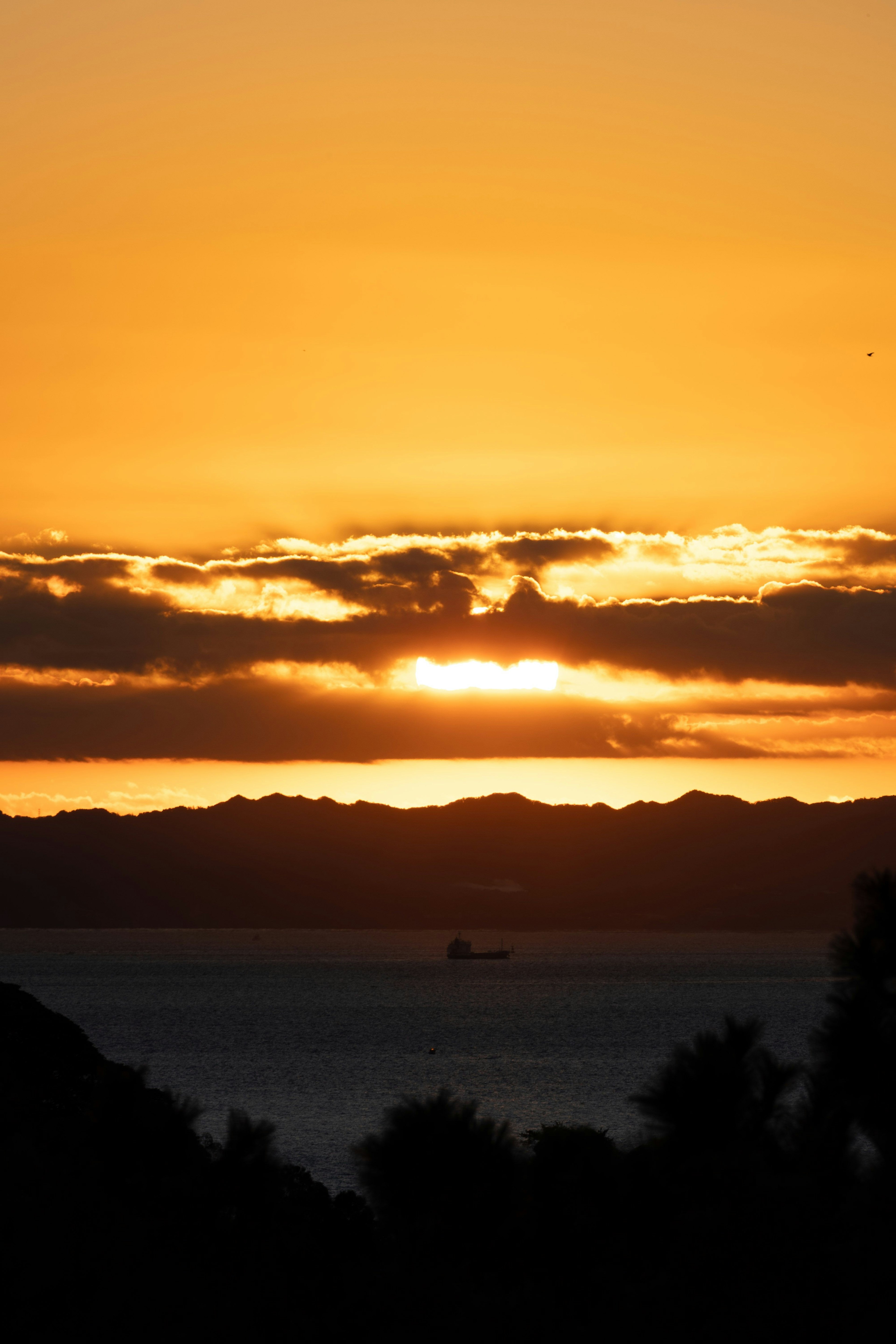 夕日が沈む海の風景 様々な色合いの雲が広がる