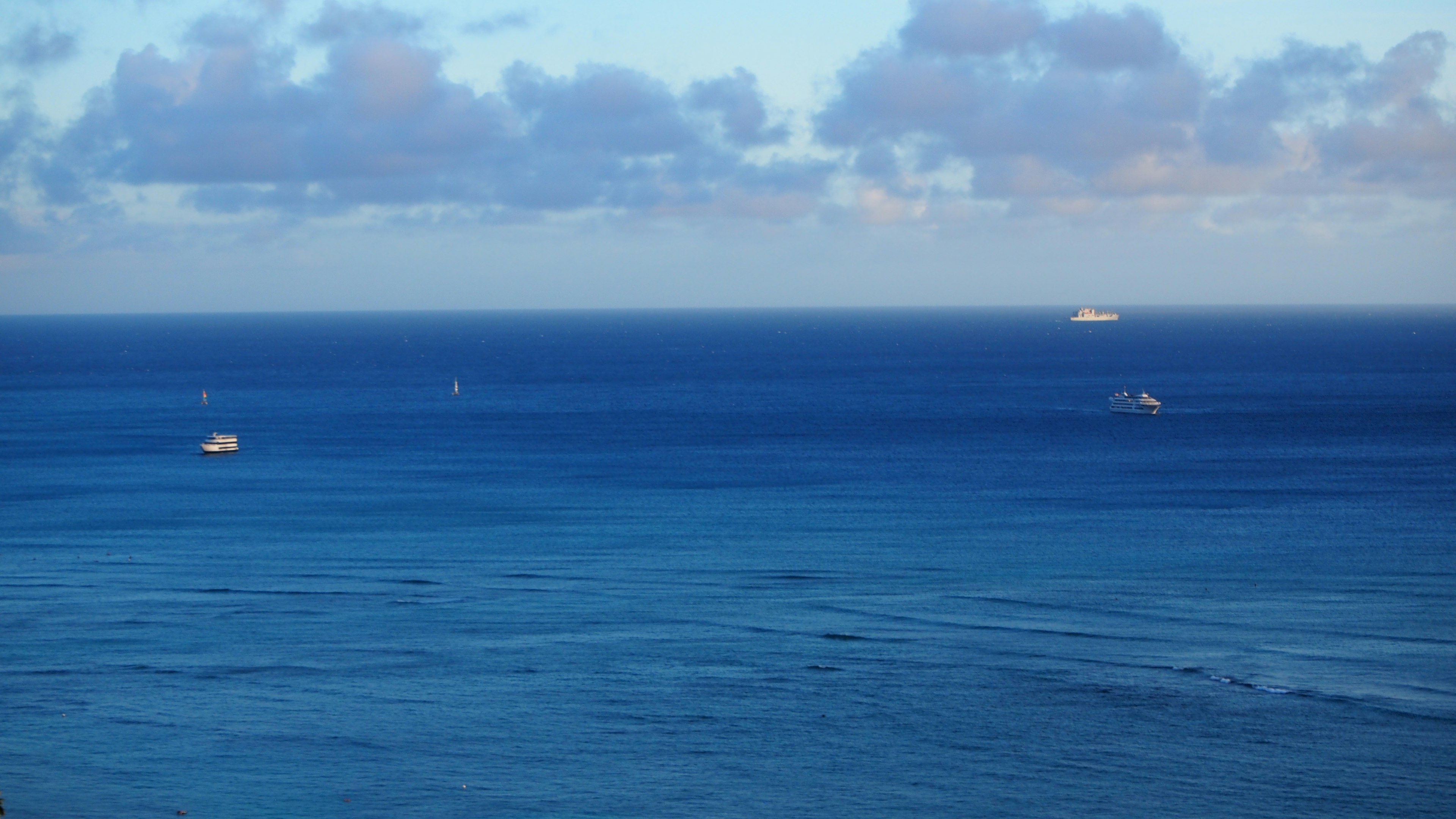 青い海と空に浮かぶ数隻の船の風景