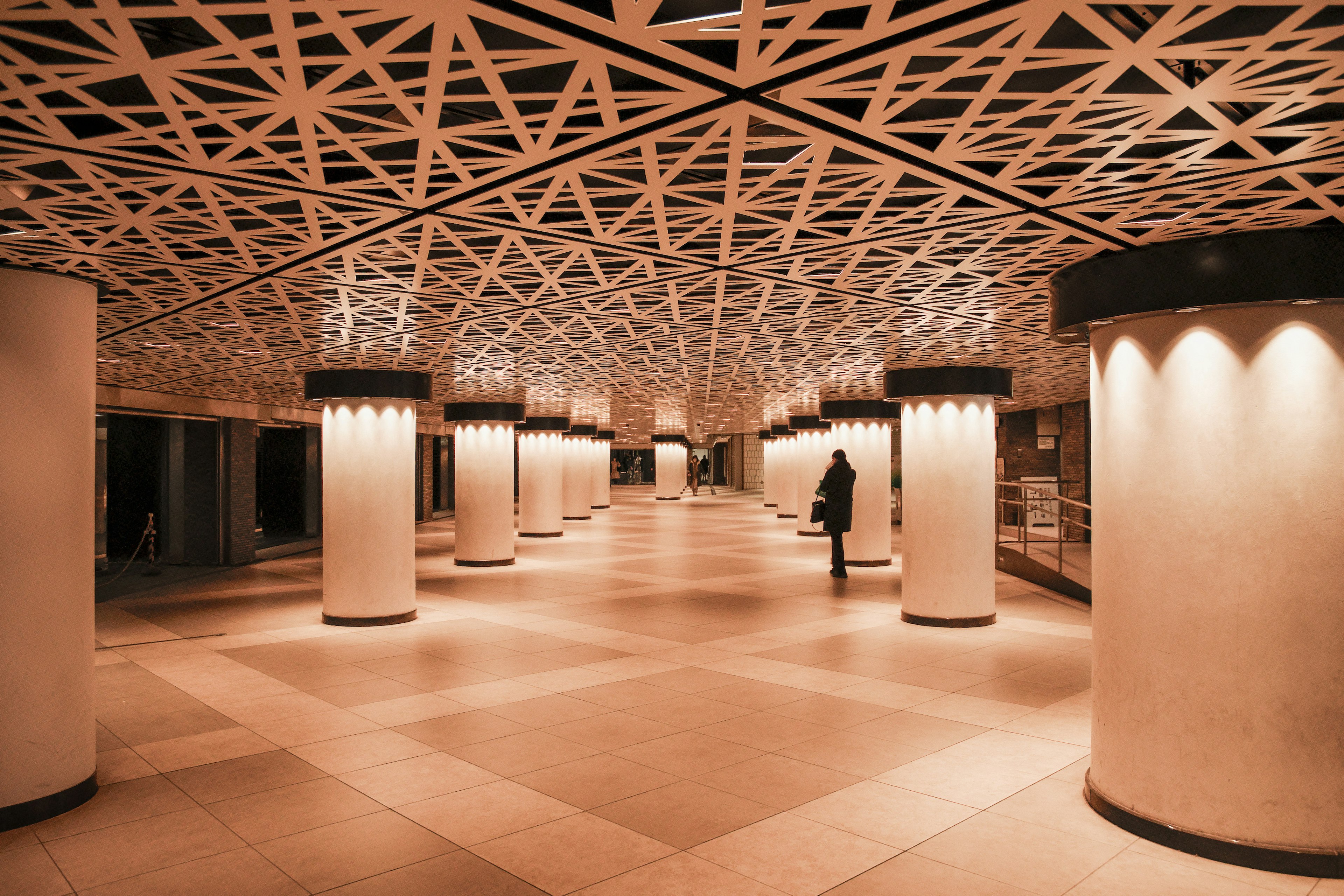 Interior view of a modern underground passage with geometric ceiling