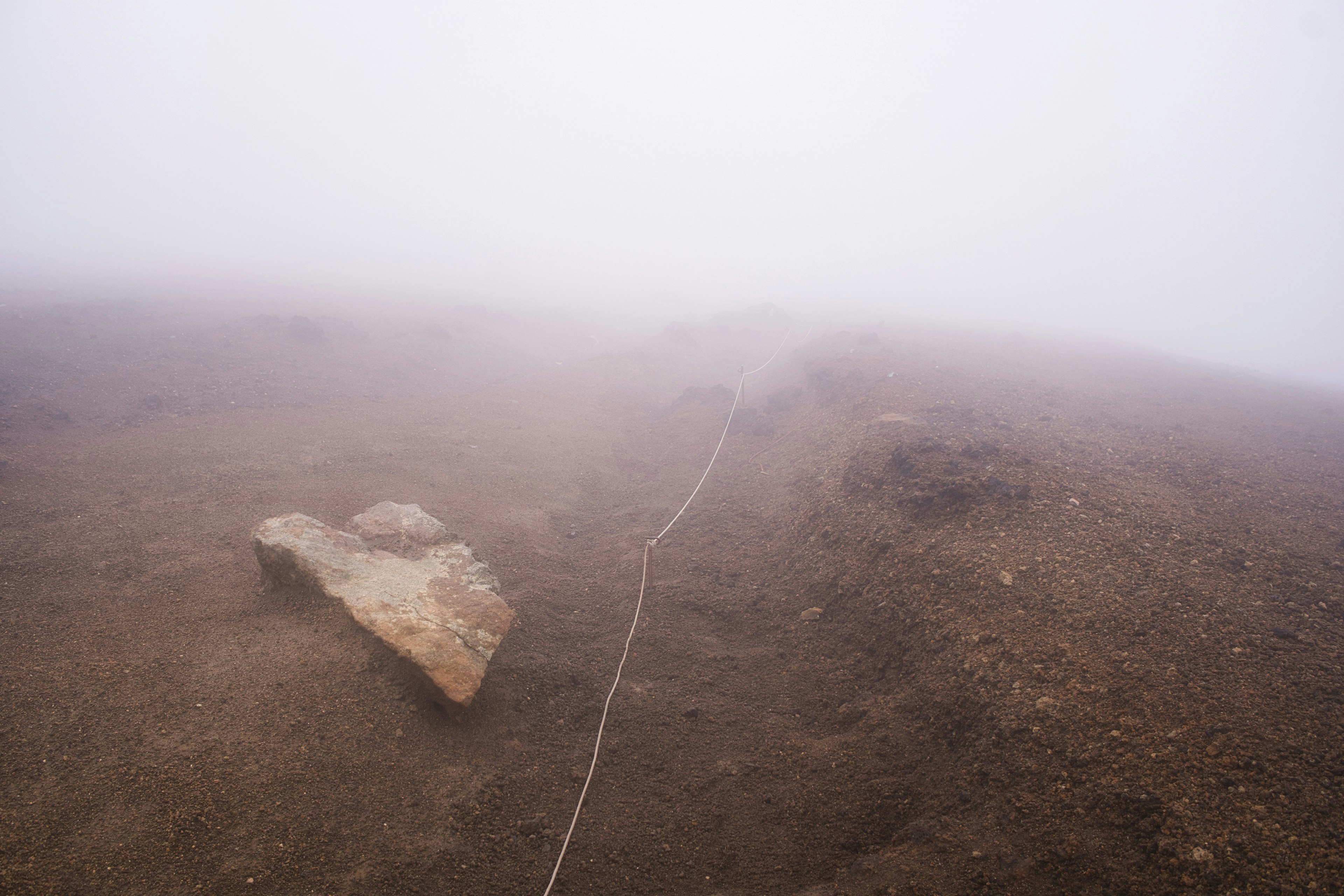 Paisaje con una roca y una cuerda en la niebla