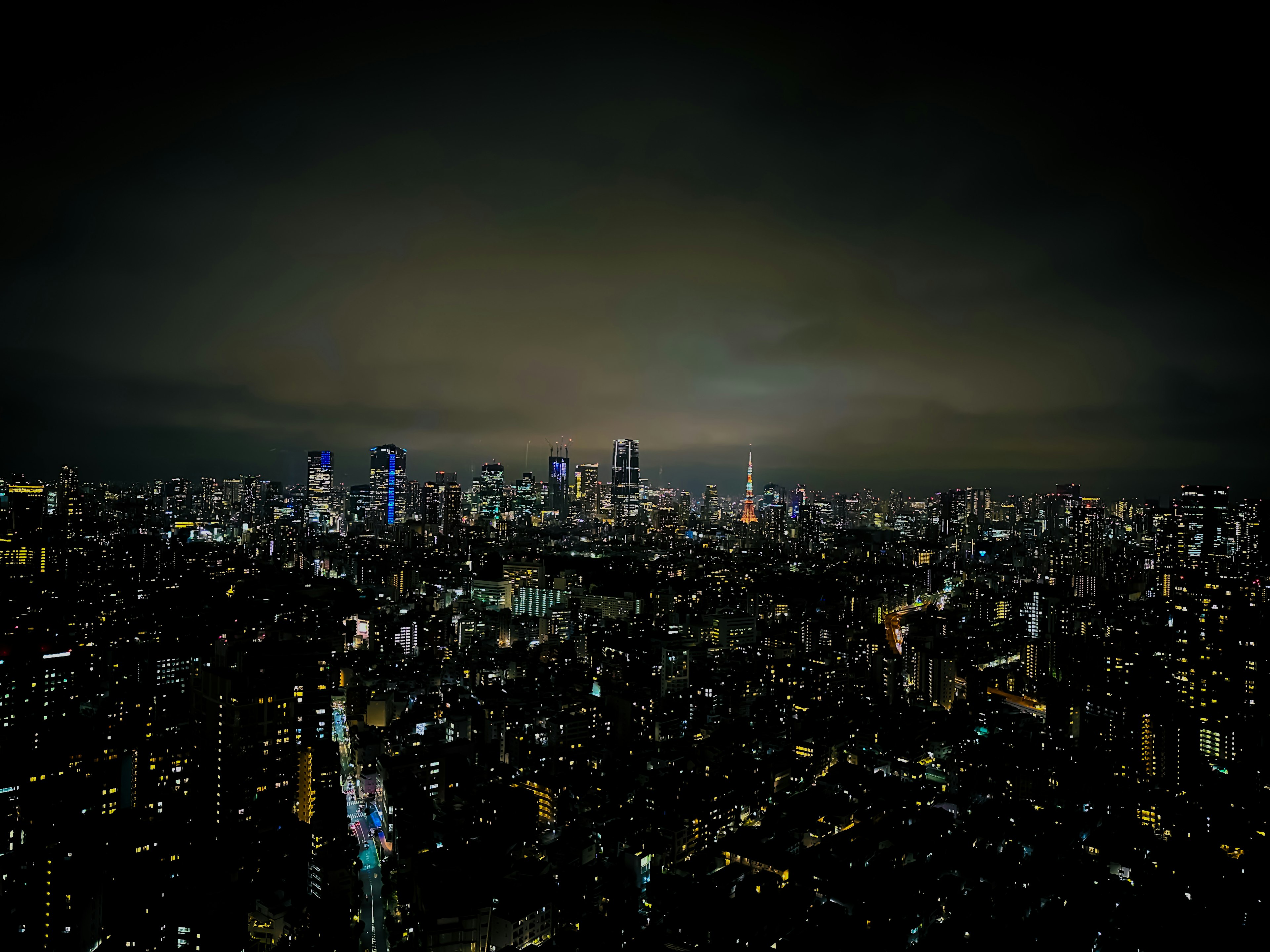 A panoramic view of Tokyo's skyline at night with illuminated skyscrapers