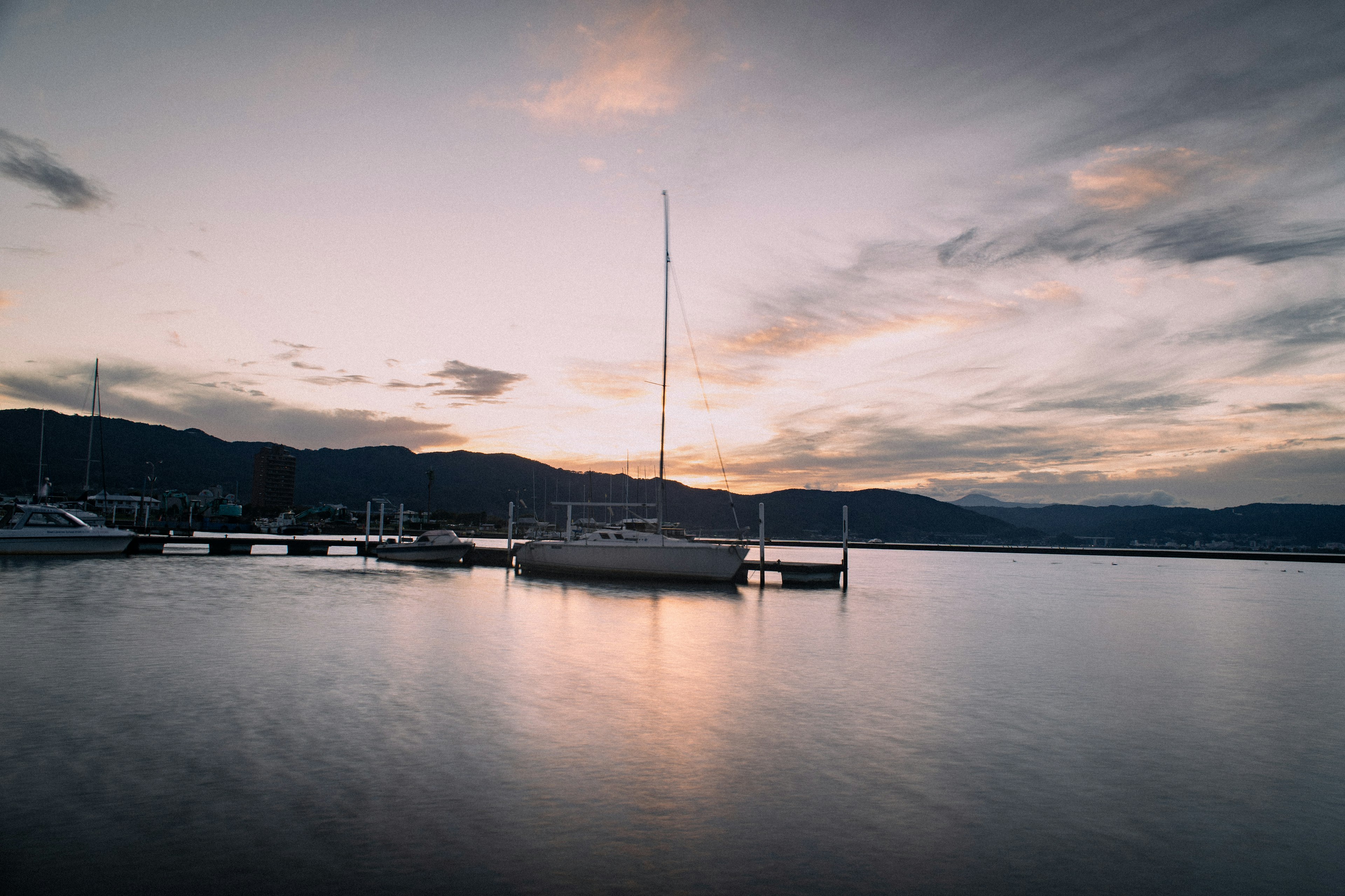 Superficie calma del lago con barche e un bellissimo tramonto