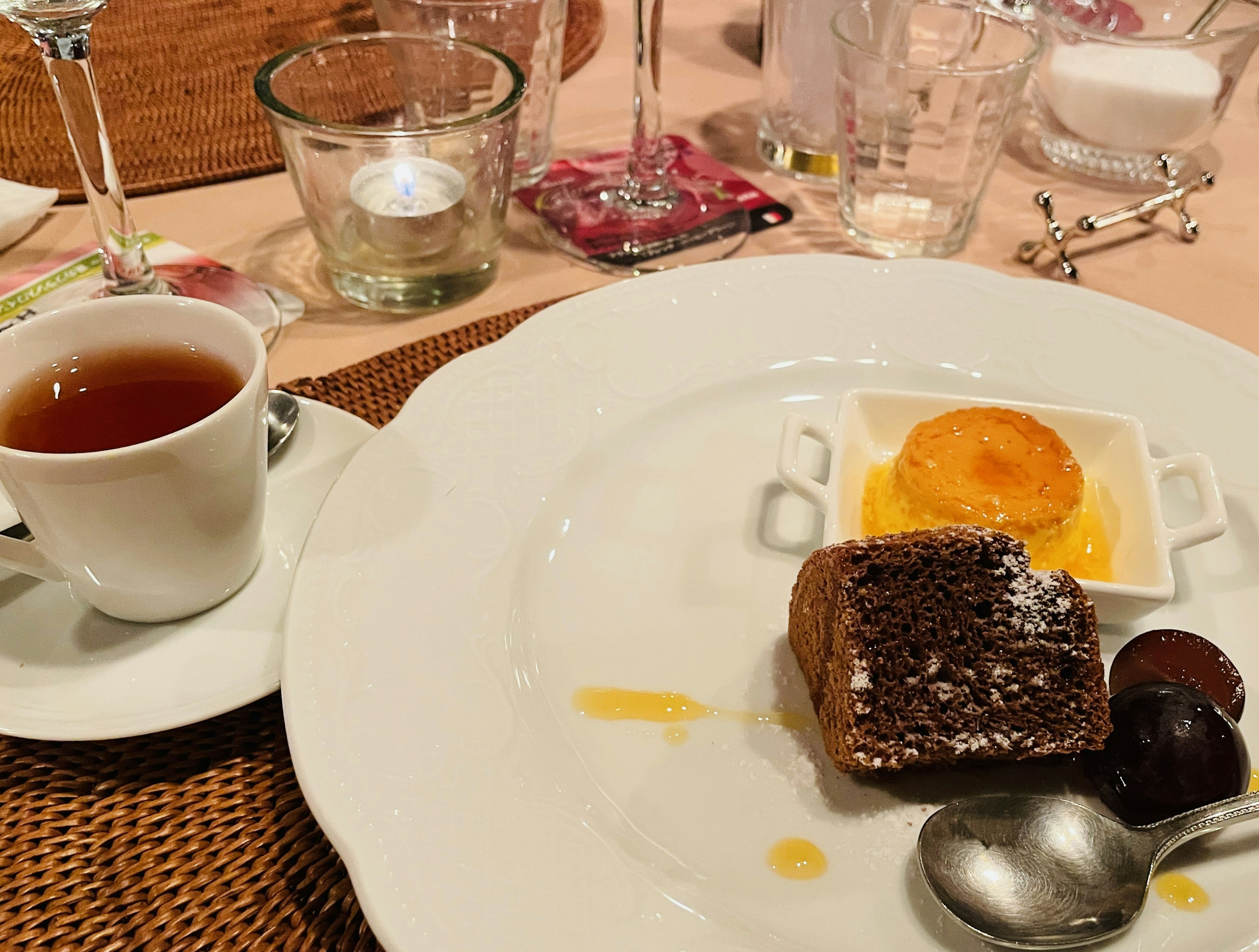 Dessert plate featuring chocolate cake and orange jelly with a cup of tea