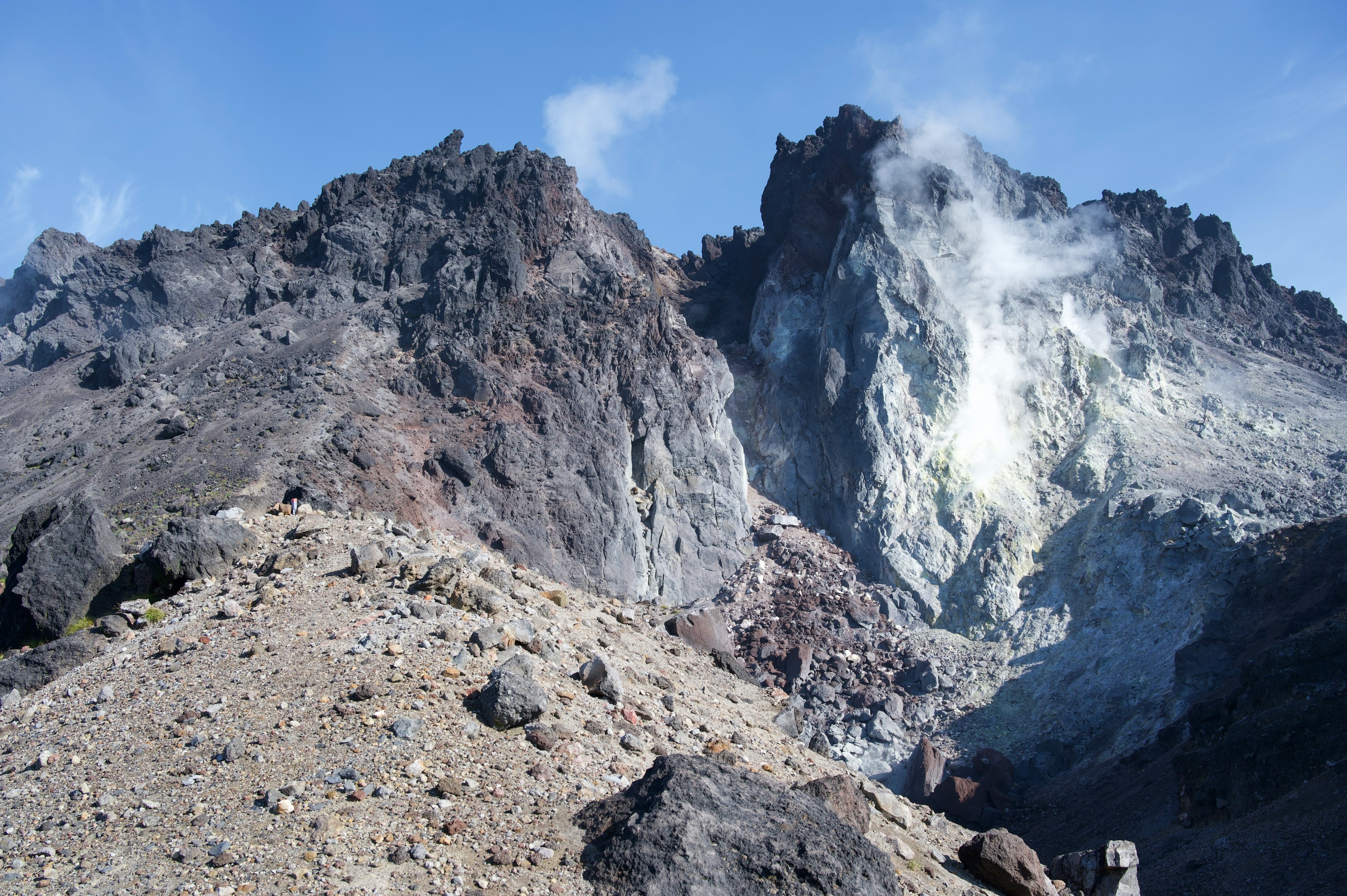 Gunung berapi curam dengan asap dan medan berbatu