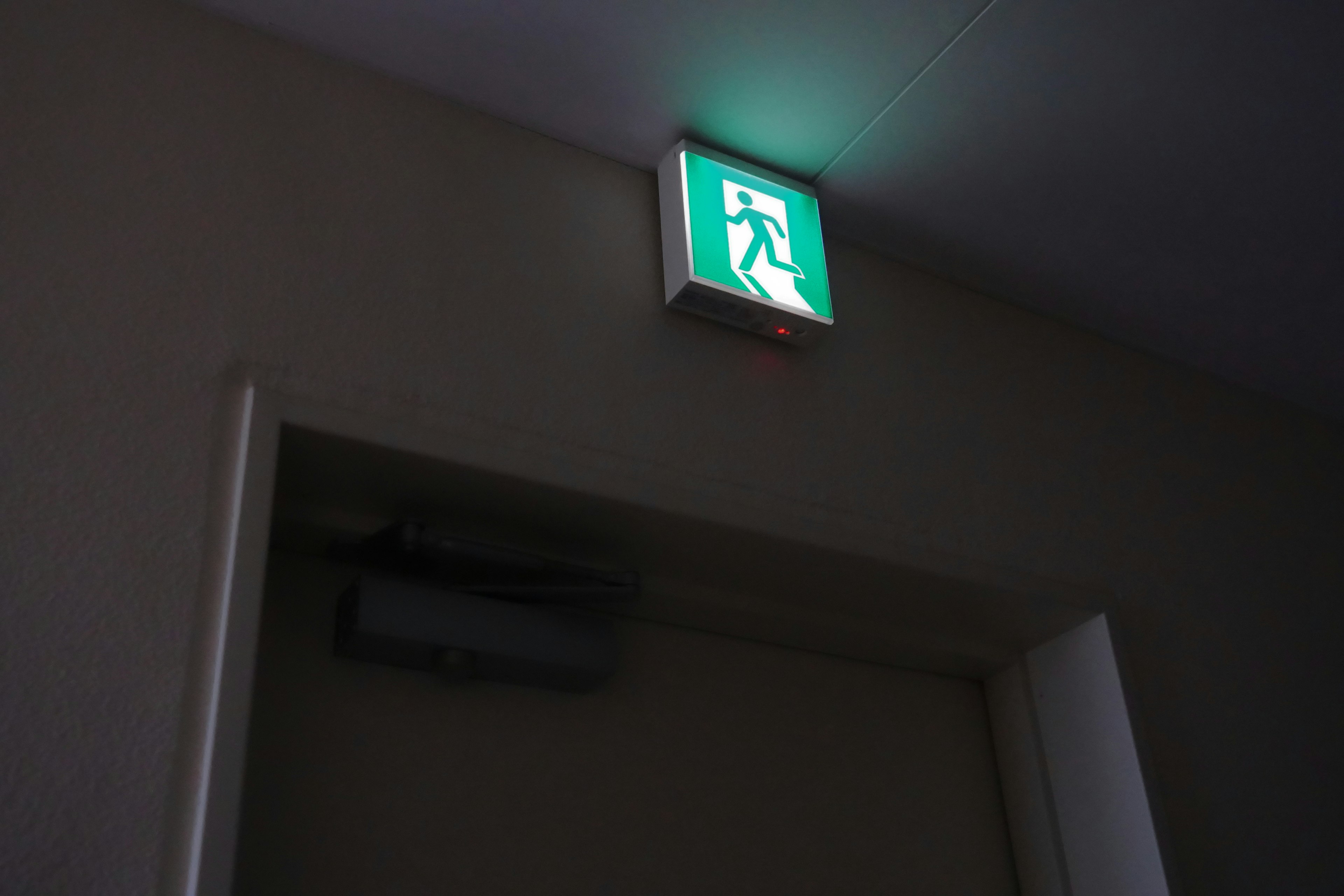 Green emergency exit sign mounted on a wall