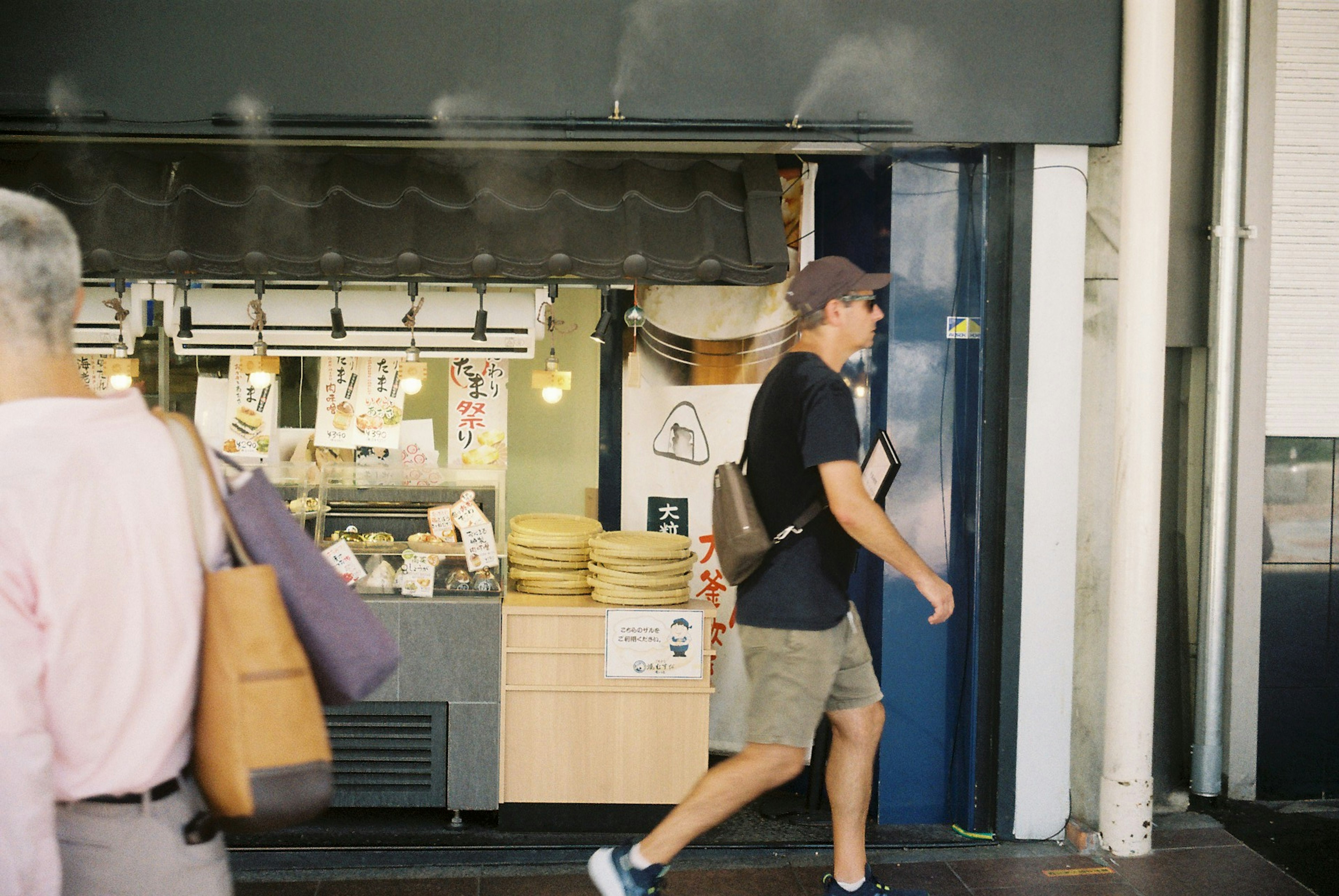 街の風景で歩く男性と飲食店の外観