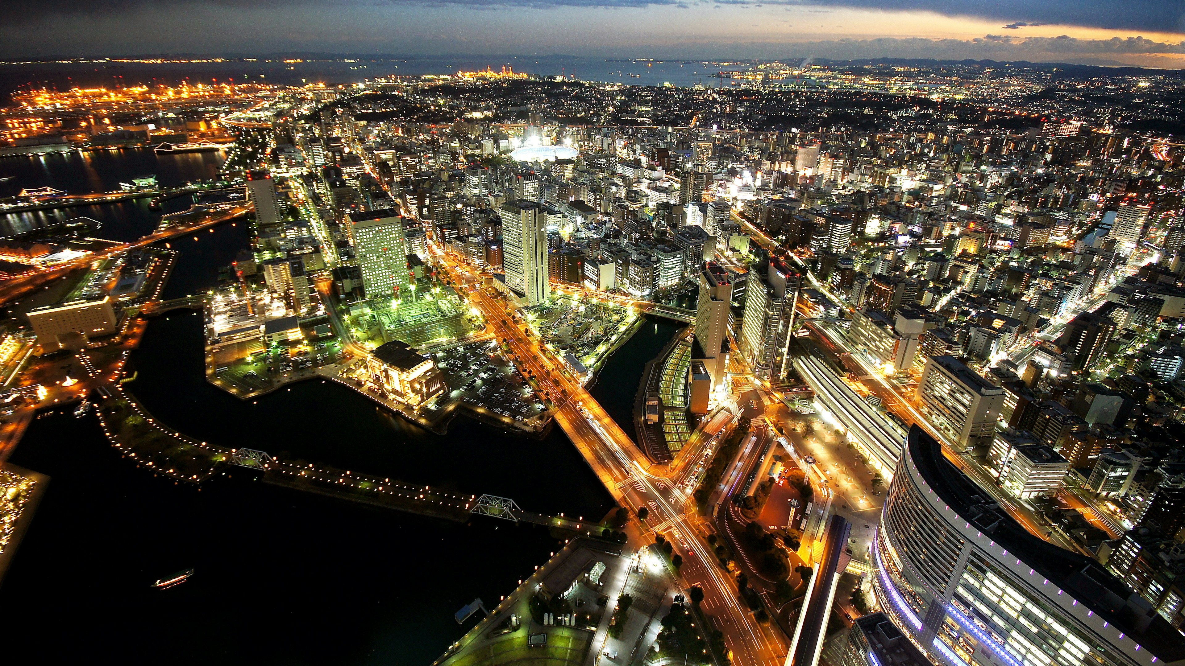 Vista panoramica di una città vibrante di notte con grattacieli illuminati e ponti