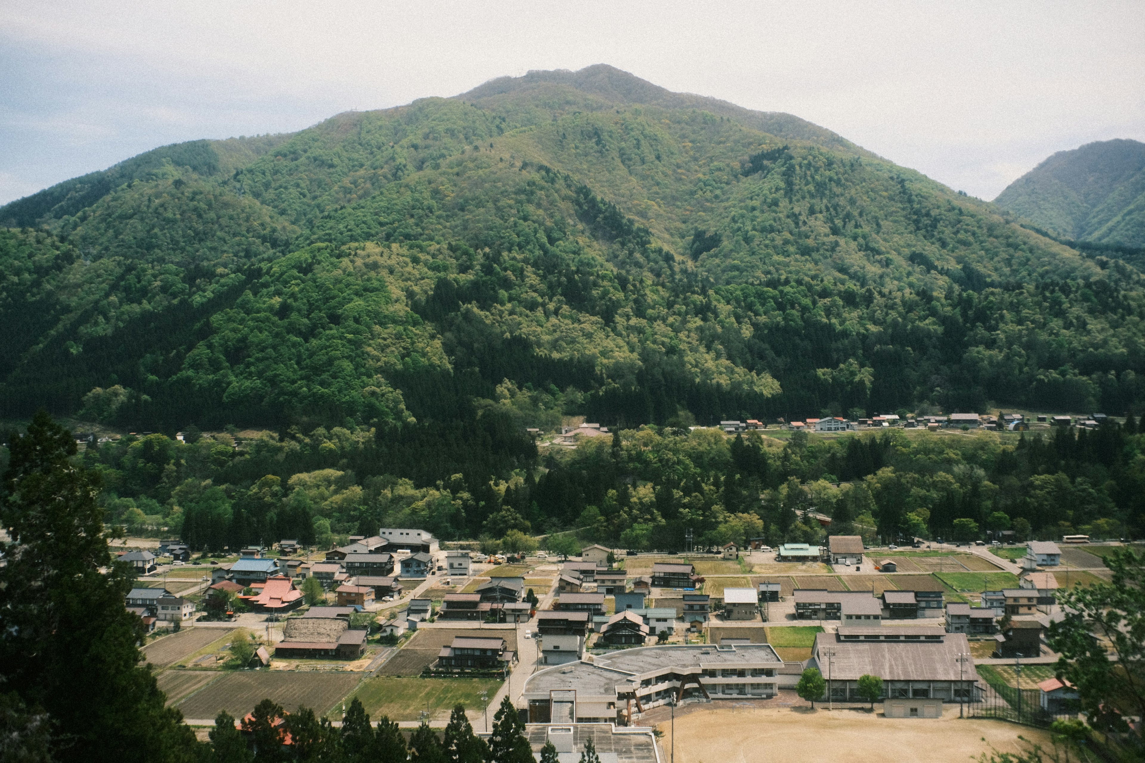 緑豊かな山々に囲まれた小さな村の風景