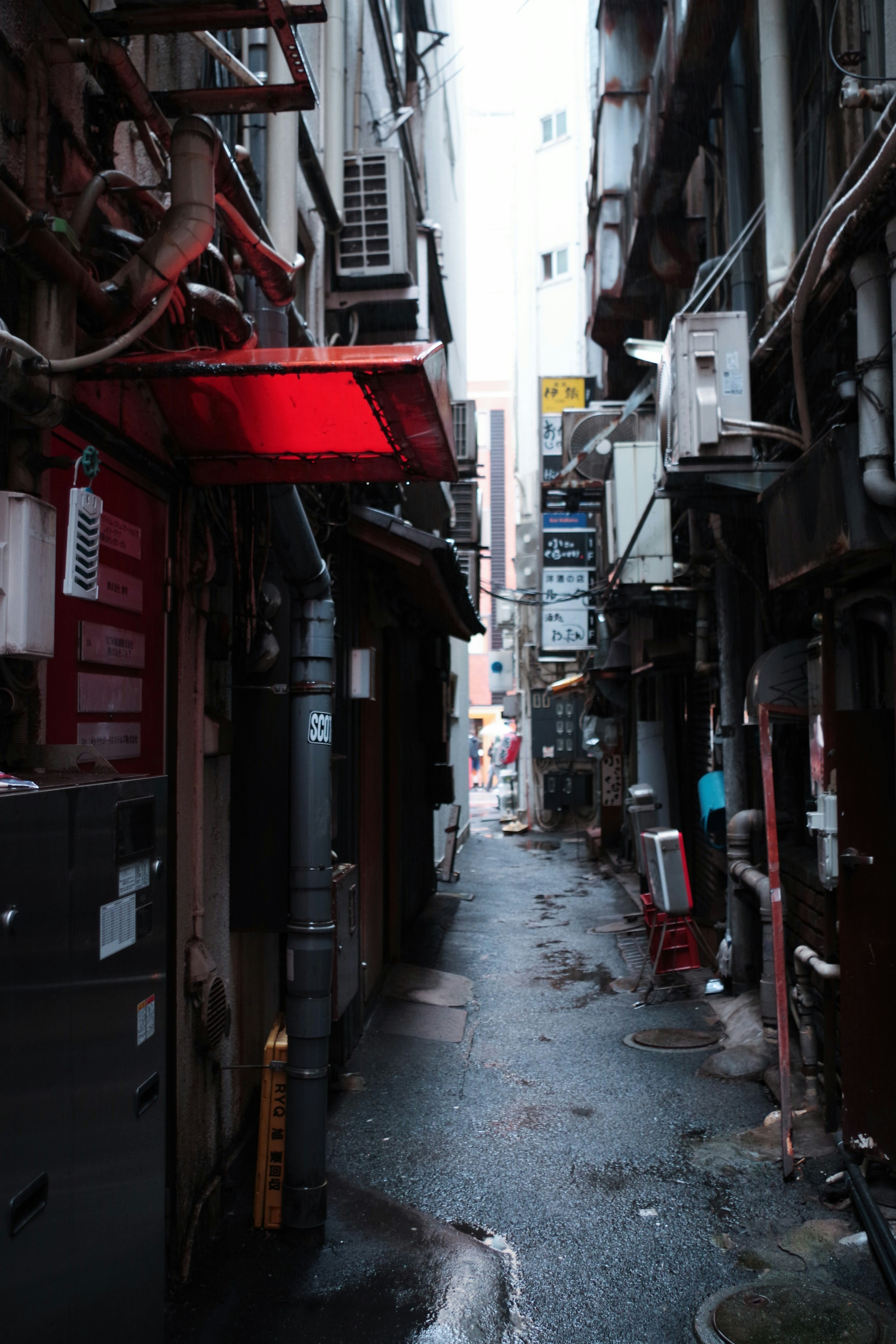 狭い路地に赤い照明が点灯している街の風景