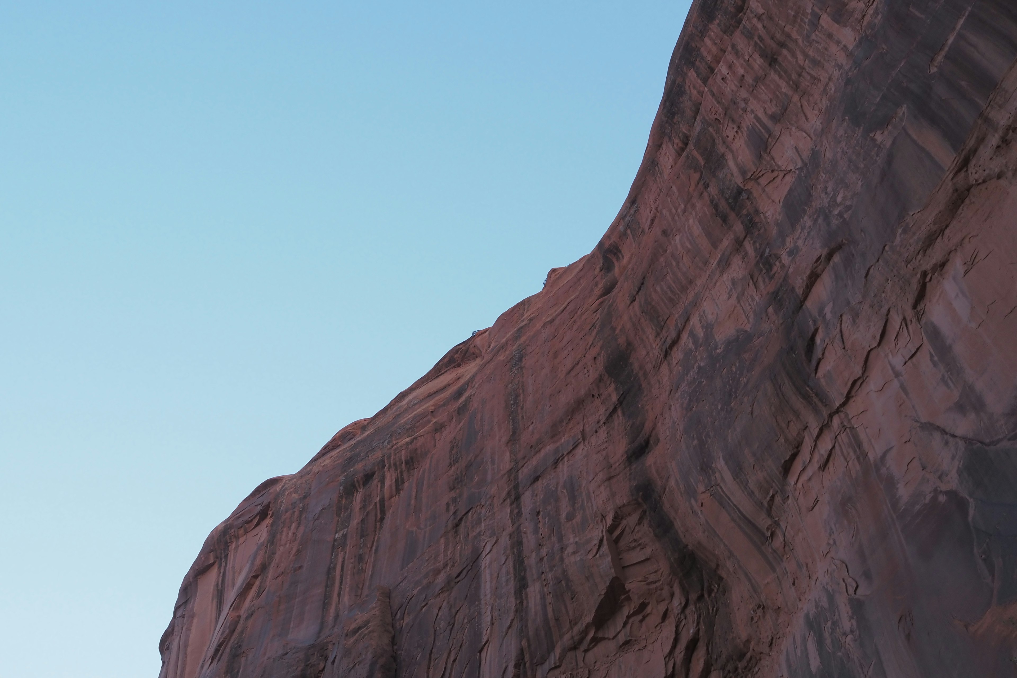 Pared de roca roja que se eleva bajo un cielo azul